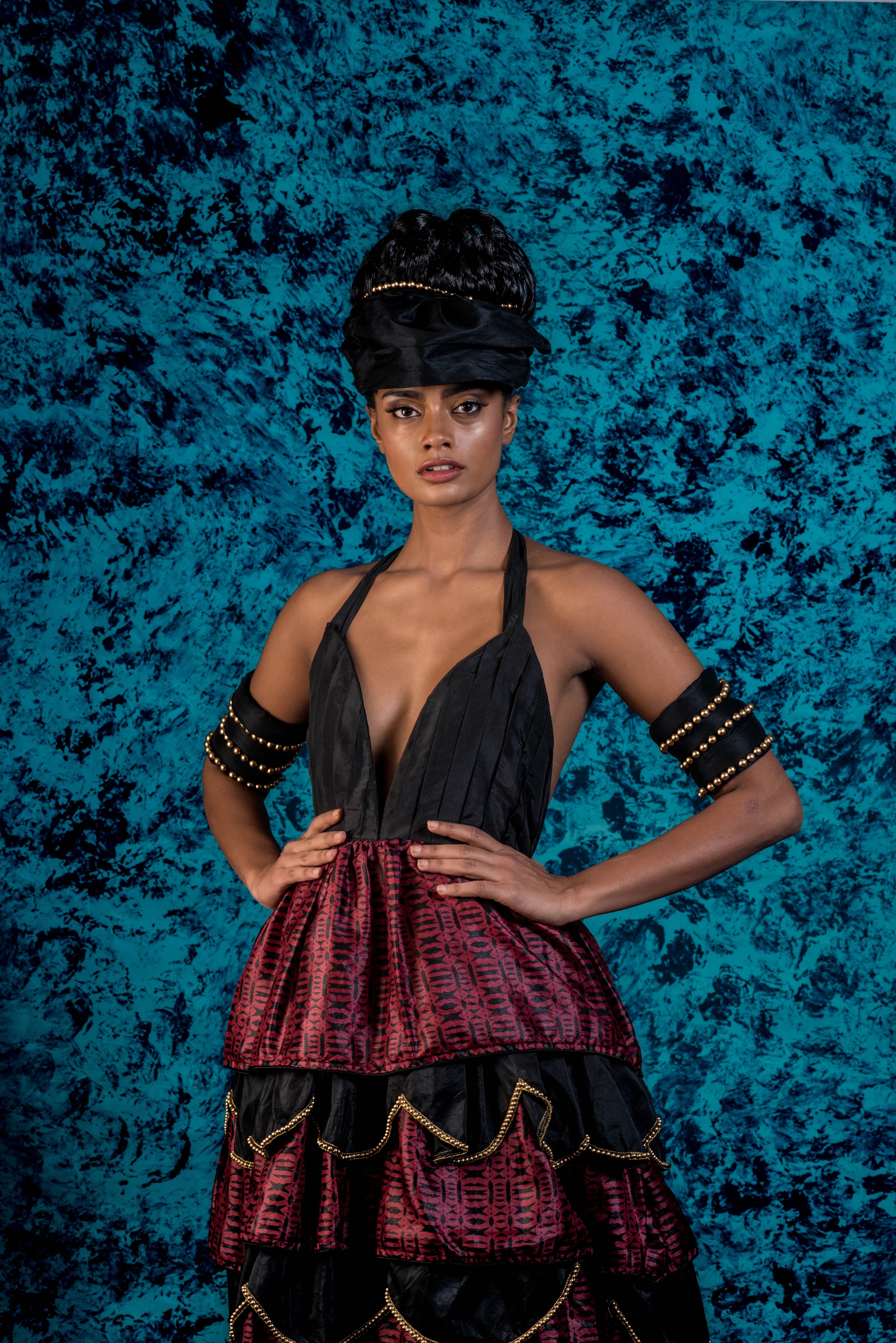 Supermodel Archana Akil Kumar posing with hand on hips in a noir halterneck gown with a multi-tiered scalloped look. Partywear Gown.