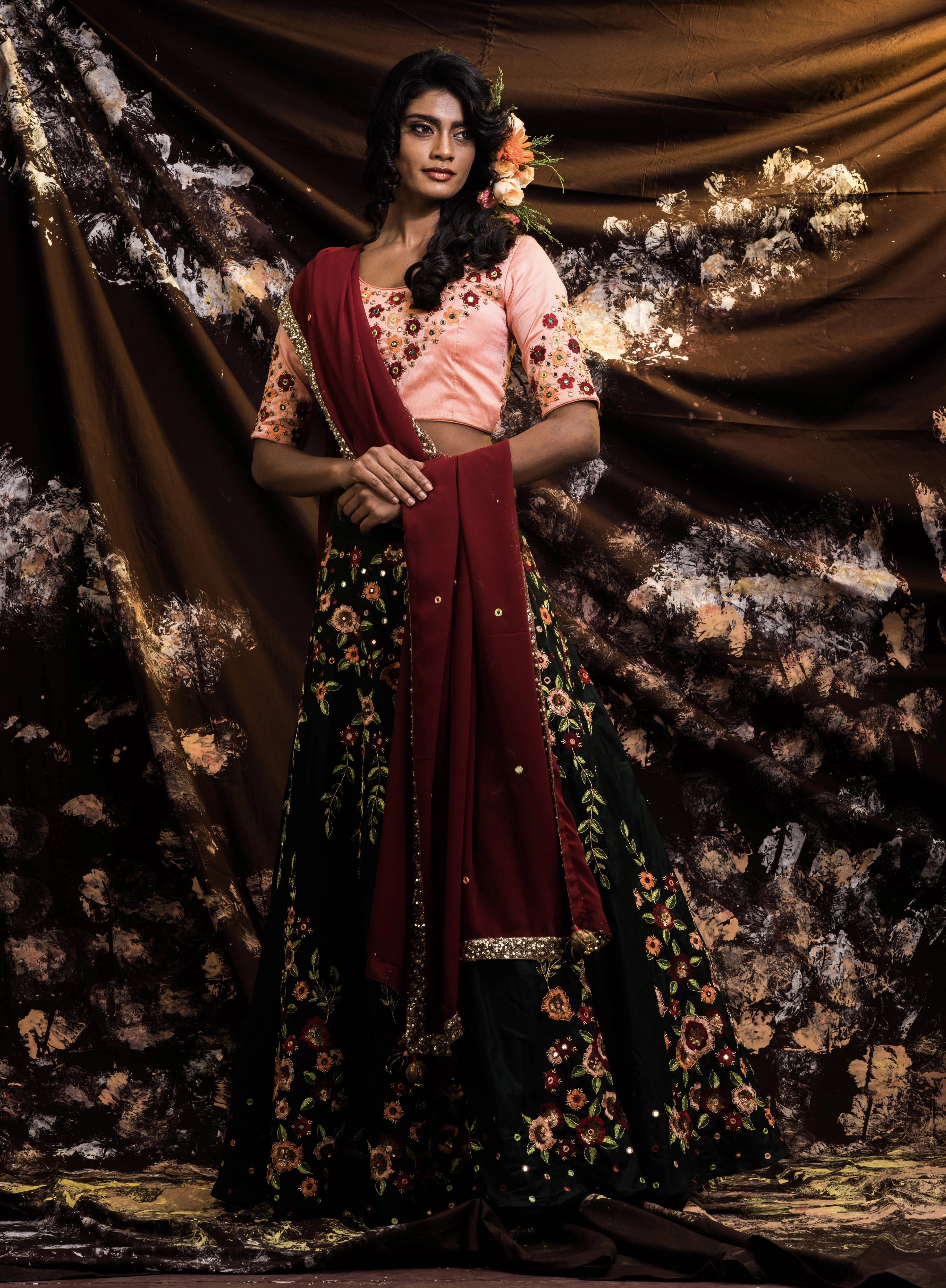 Supermodel Archana Akil Kumar smiling in a rawsilk peach and bottle green lehenga with a maroon georgette dupatta intricately handcrafted by team Archana Karthick.
