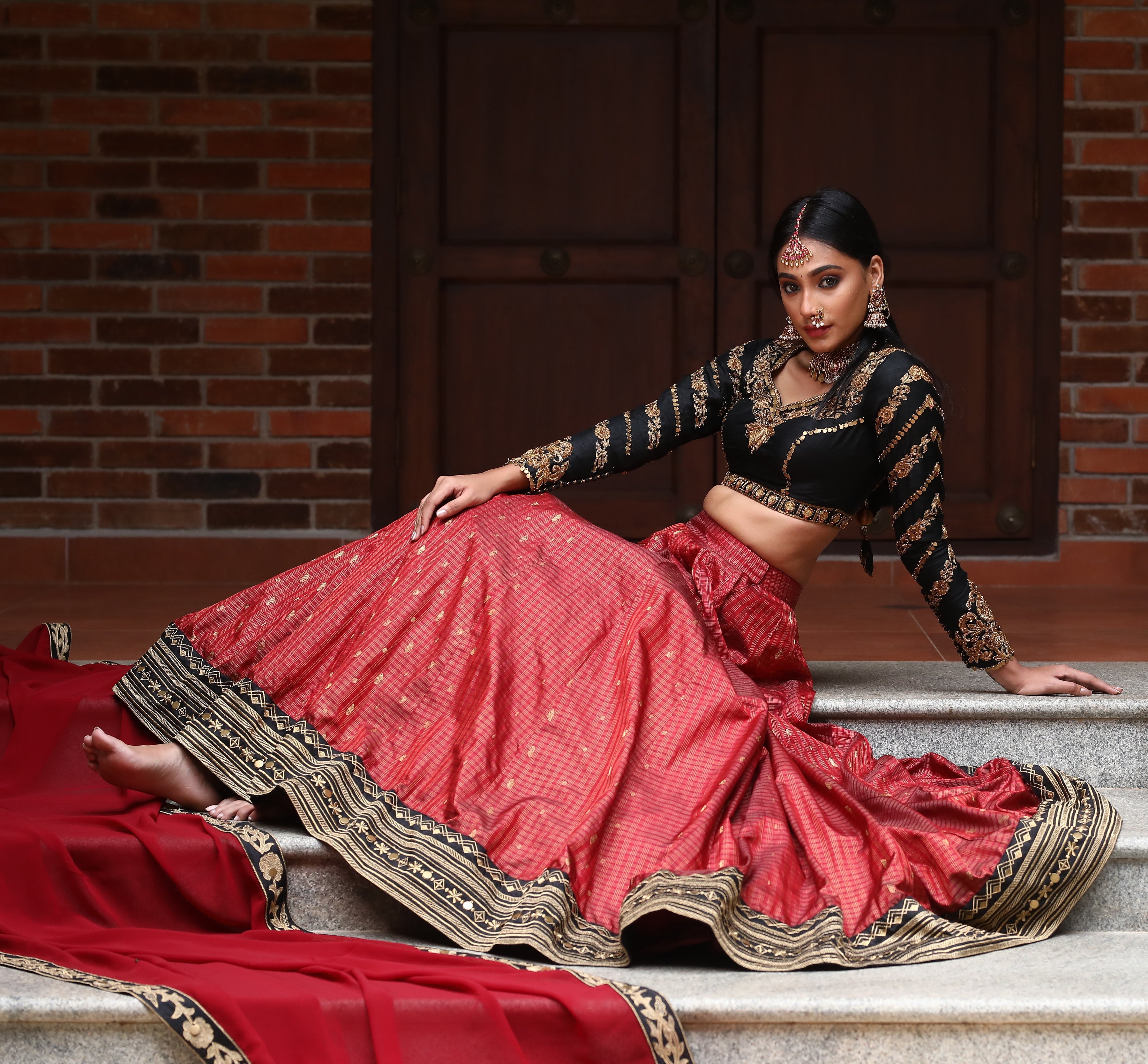 miss india 2018 and actress Anukreethy Vas in lehenga designed by archana karthick posing sitting sideways on stairs