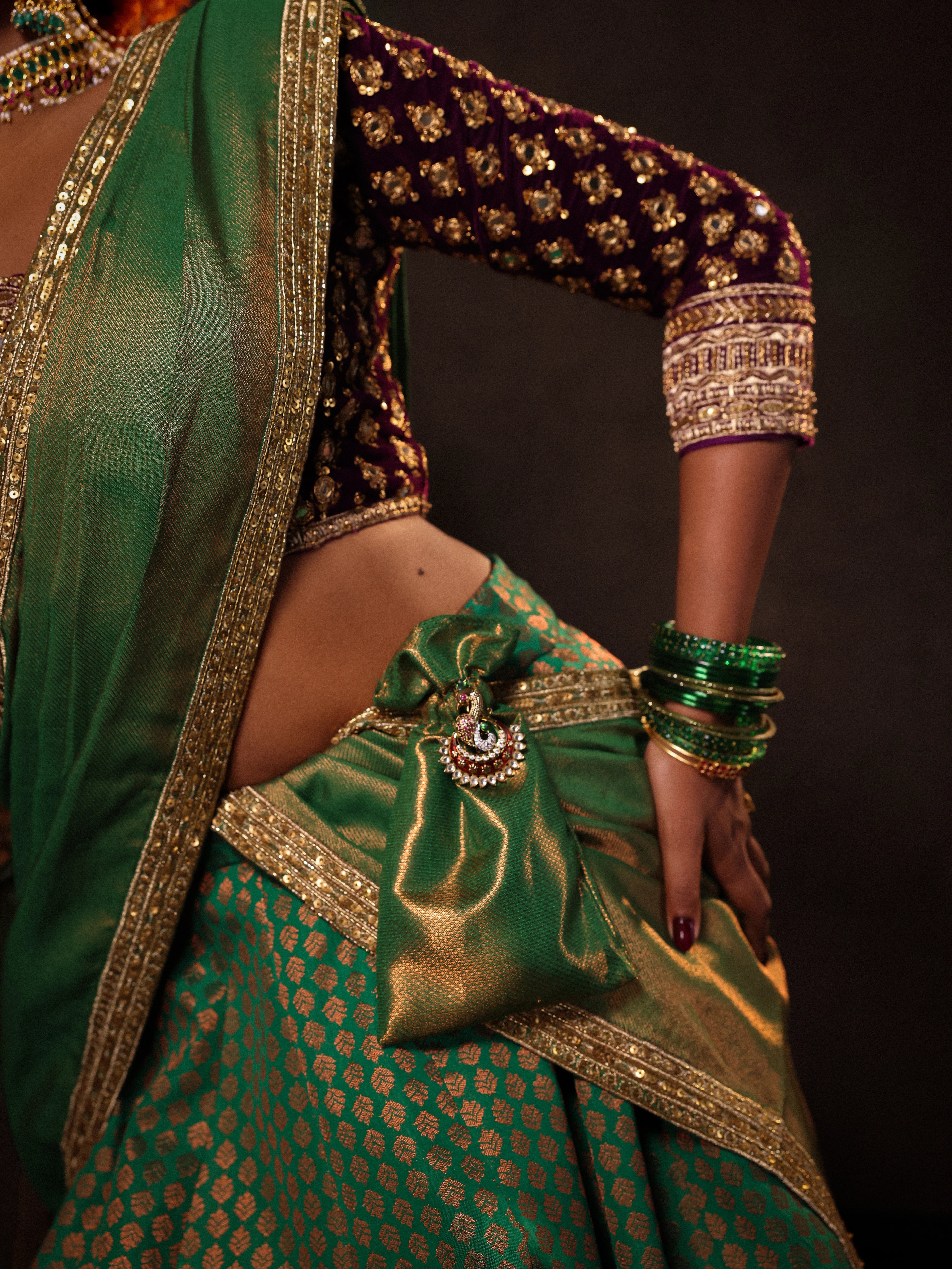 Model Ashika in purple & green banarasi brocade silk half saree with glass bangles and jewellery from NAC jewellers.