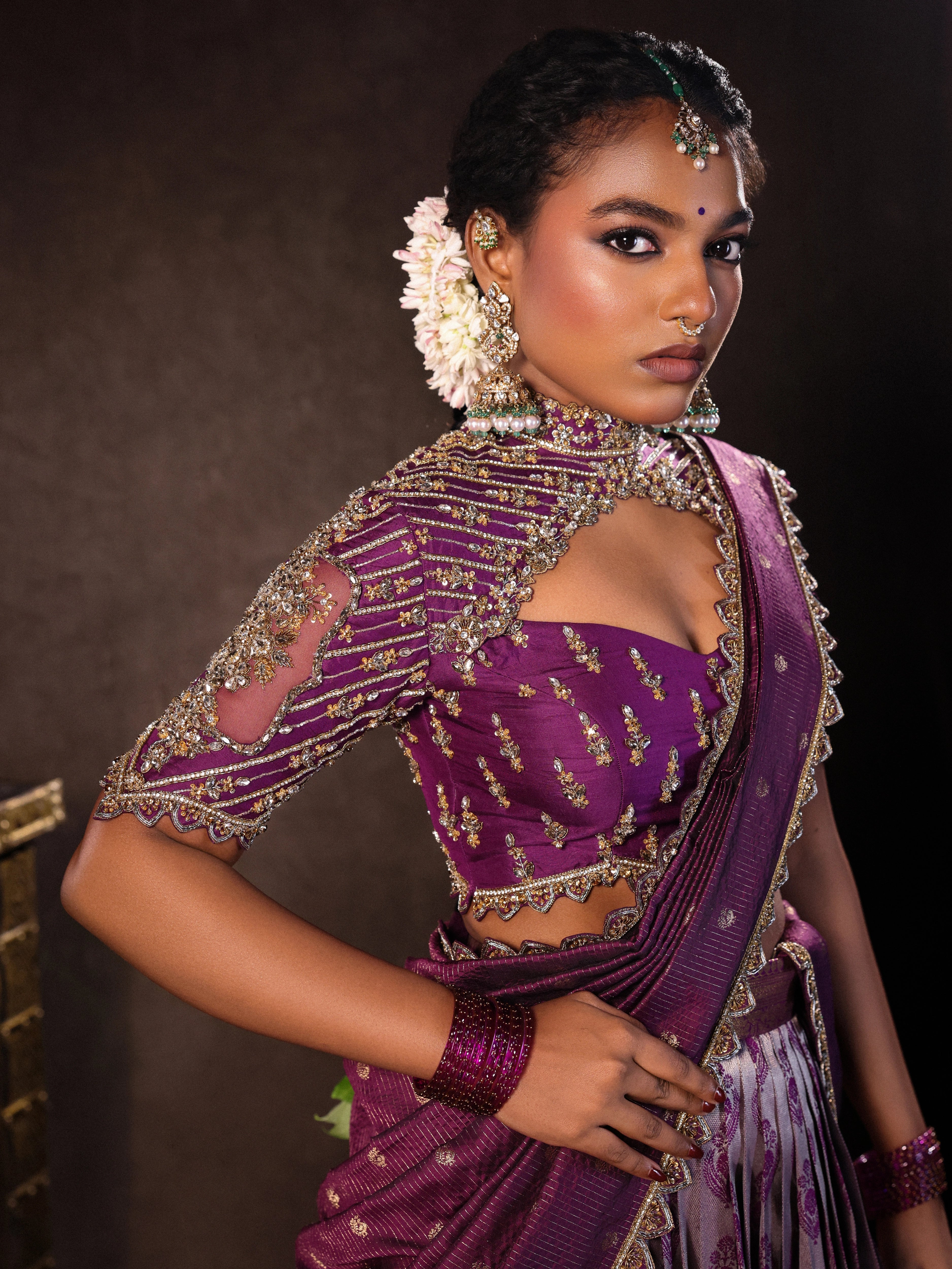 Model Ashika pose in purple kanjeevaram silk half saree with glass bangles and jewellery from NAC