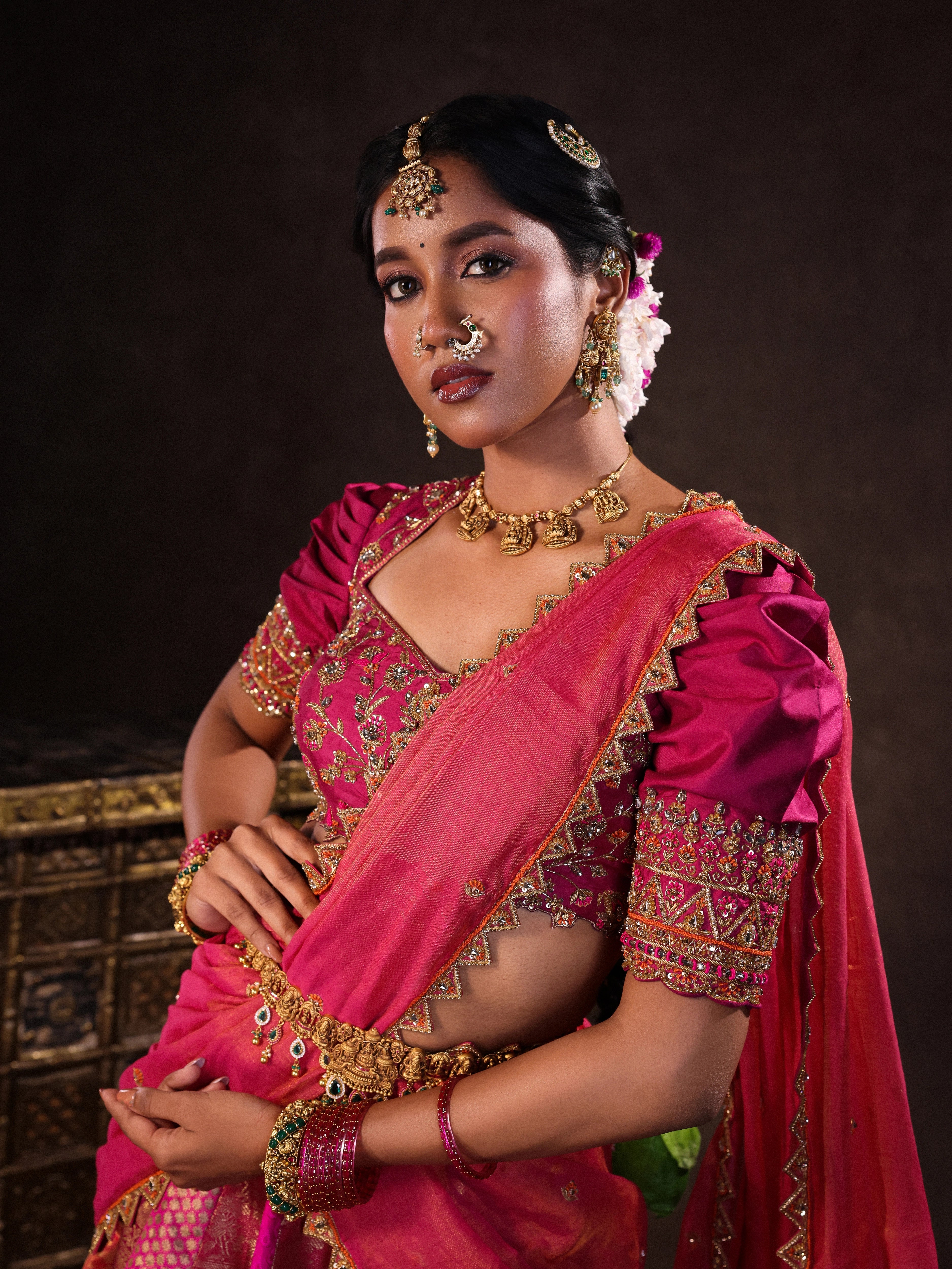Model Gayathri Dhanasekar in pink & orange kanjeevaram silk half saree blouse with glass bangles and NAC jewellery.