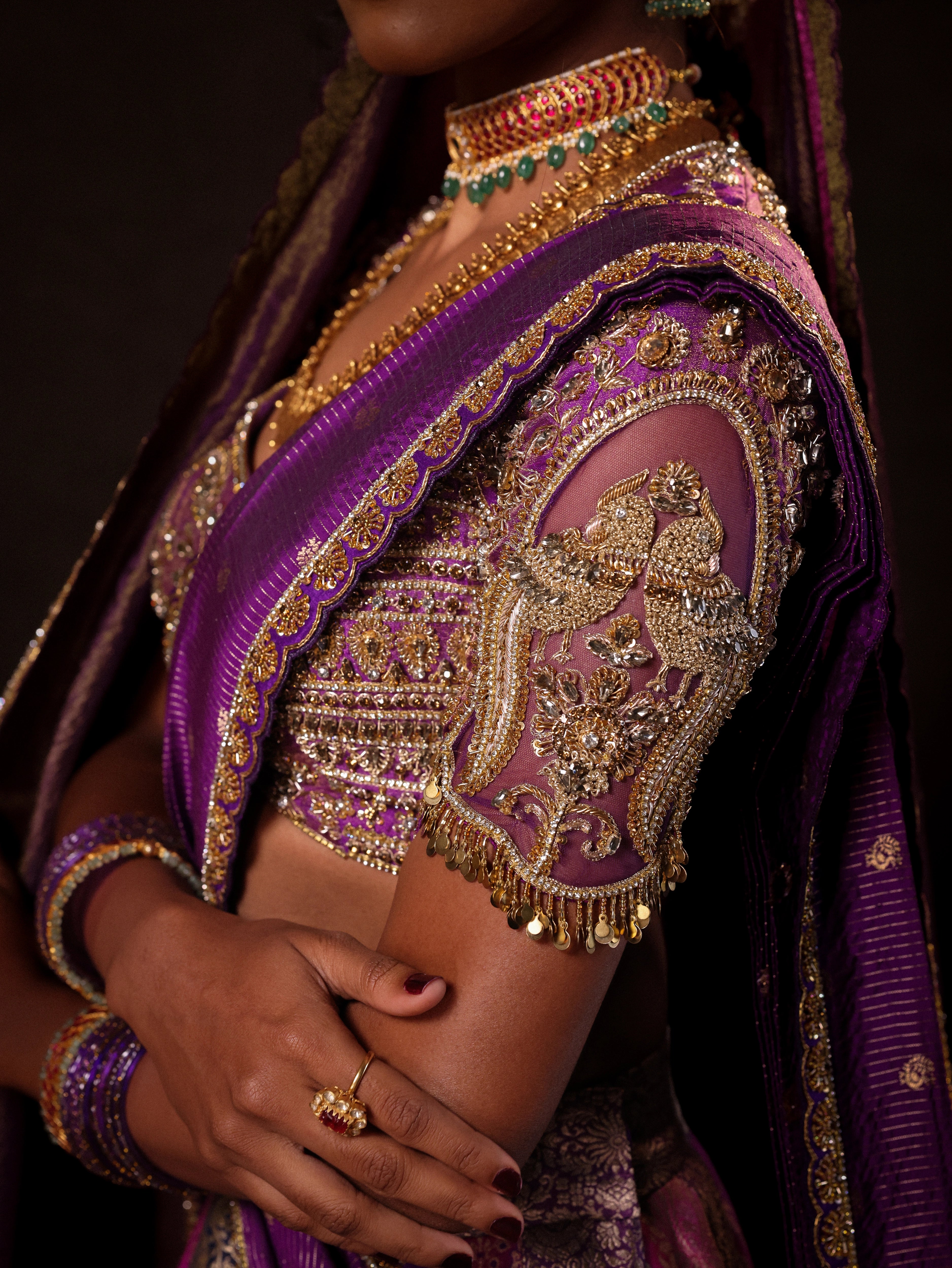 Model Gayathri Dhanasekar in a purple banarasi brocade silk half saree blouse sleeve with glass bangles and NAC jewellery.