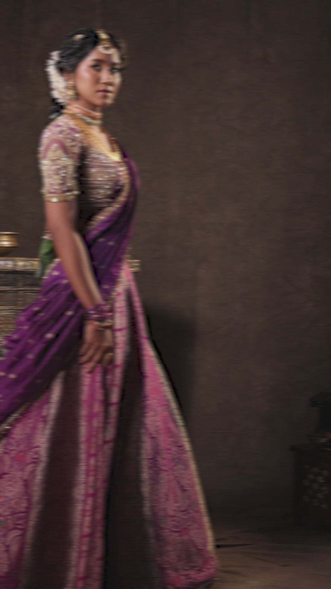 Model Gayathri Dhanasekar in a video for brand photoshoot in a silk half saree in shades of purple with a scalloped veil is handrcrafted with sequins, cutdana, resham, stones and exquisite hangings by team Archana Karthick.