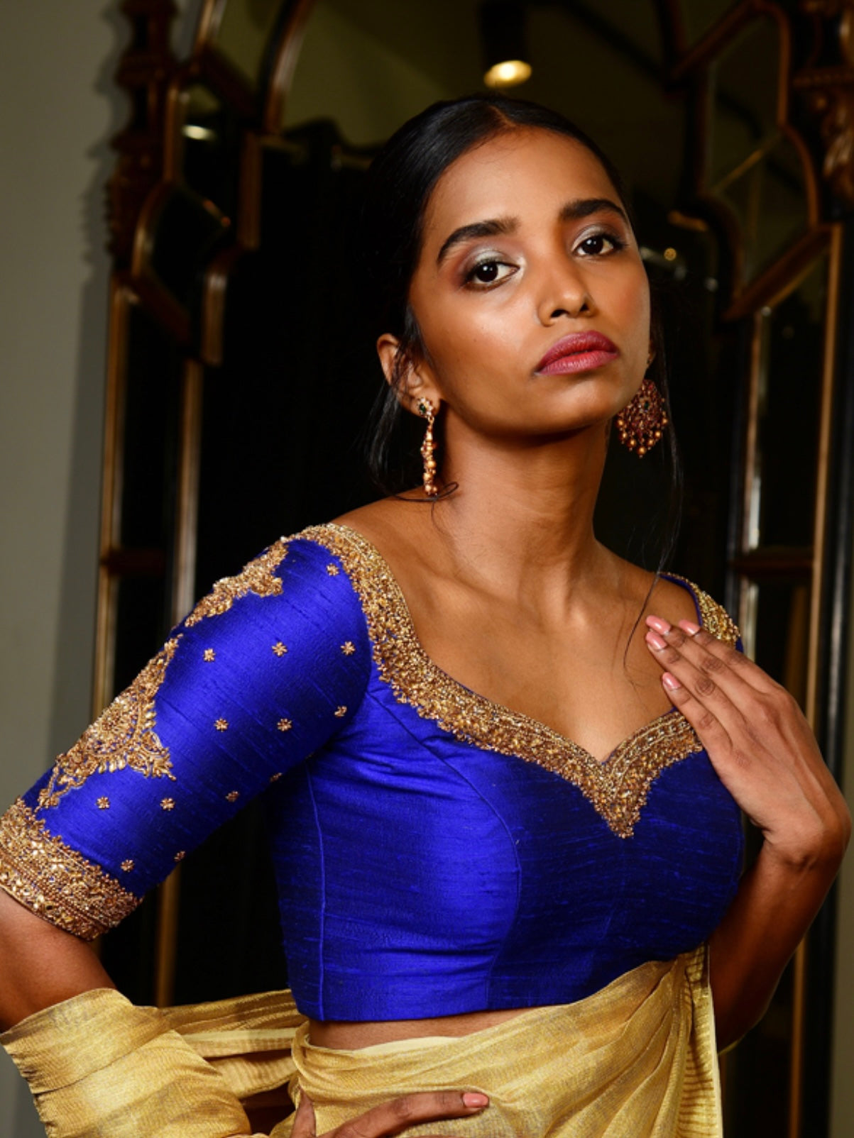 Model posing in Handcrafted Raw Silk blouse in blue with intricate zardozi work on the sleeves and neckline designed by Archana Karthick.