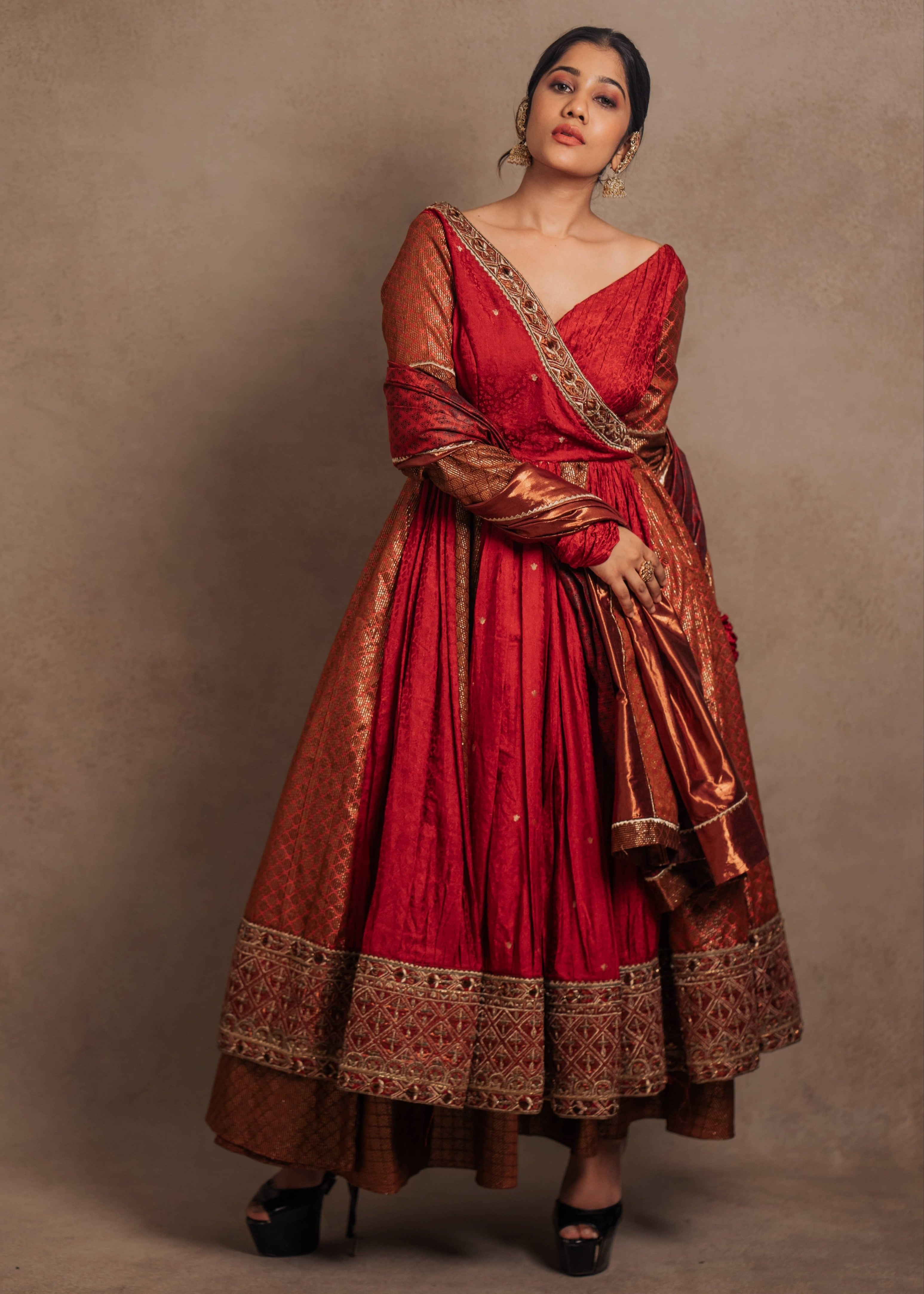 A Red-orange angrakha anarkali in banarasi tissue and silk paired with a sharara pant and a delicate tissue dupatta by team Archana Karthick