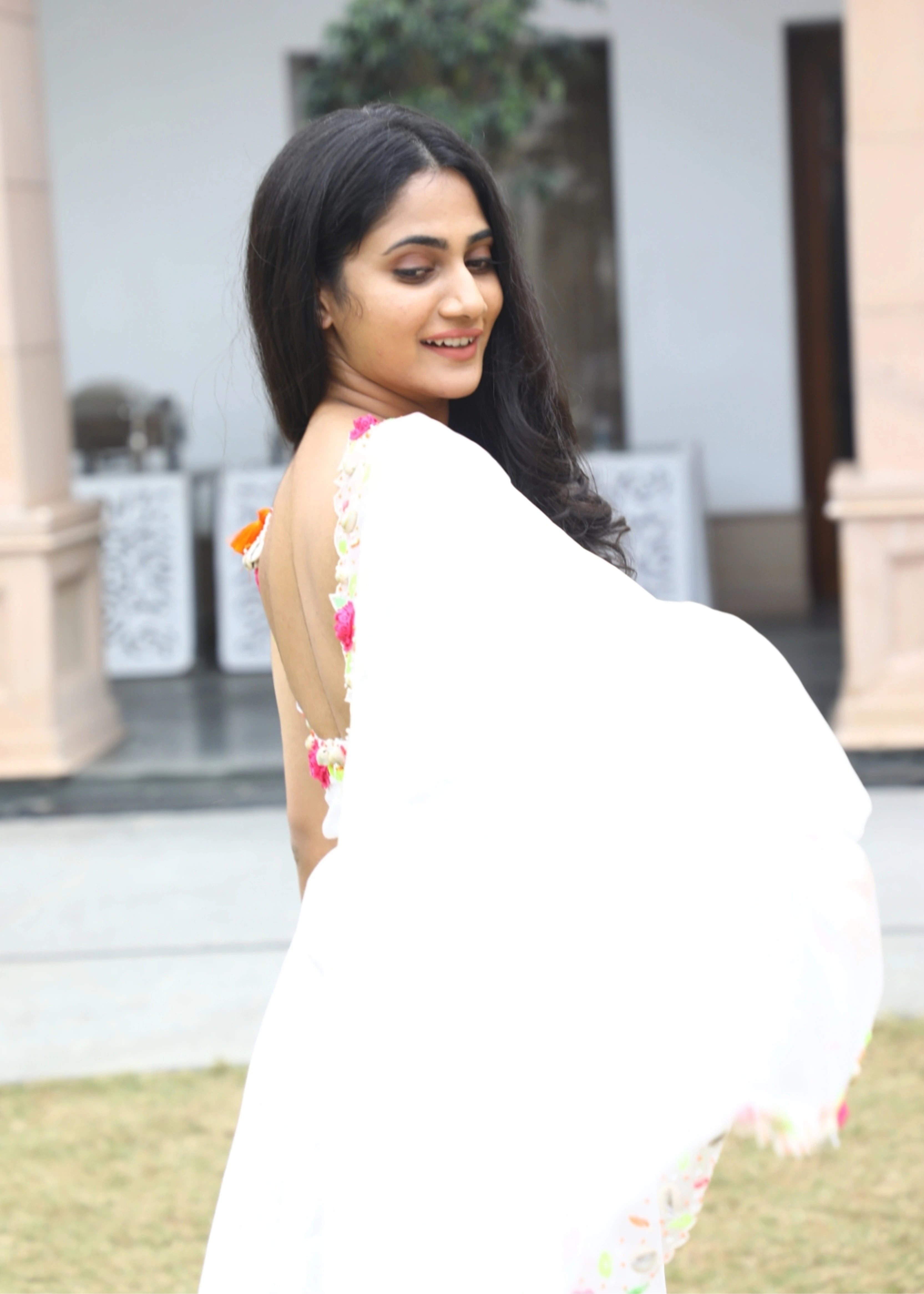 Actor and Influencer Losliya Mariyanesan showcasing back design in a gharara set handcrafted with handmade 3D Flowers, pom poms and sea shells. Designed by Archana Karthick