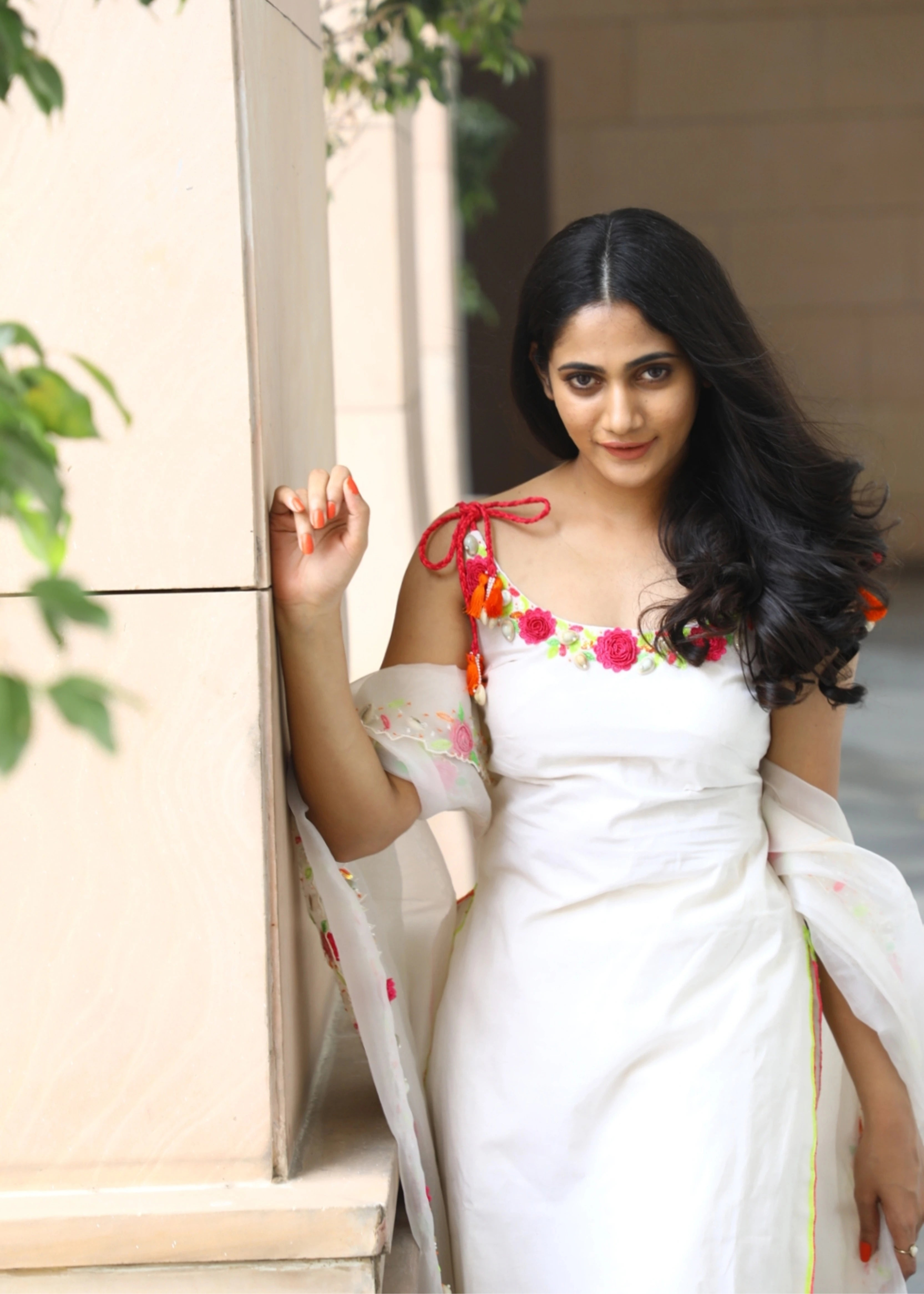 Actor and Influencer Losliya Mariyanesan smiling in a gharara set handcrafted with handmade 3D Flowers, pom poms and sea shells. Designed by Archana Karthick