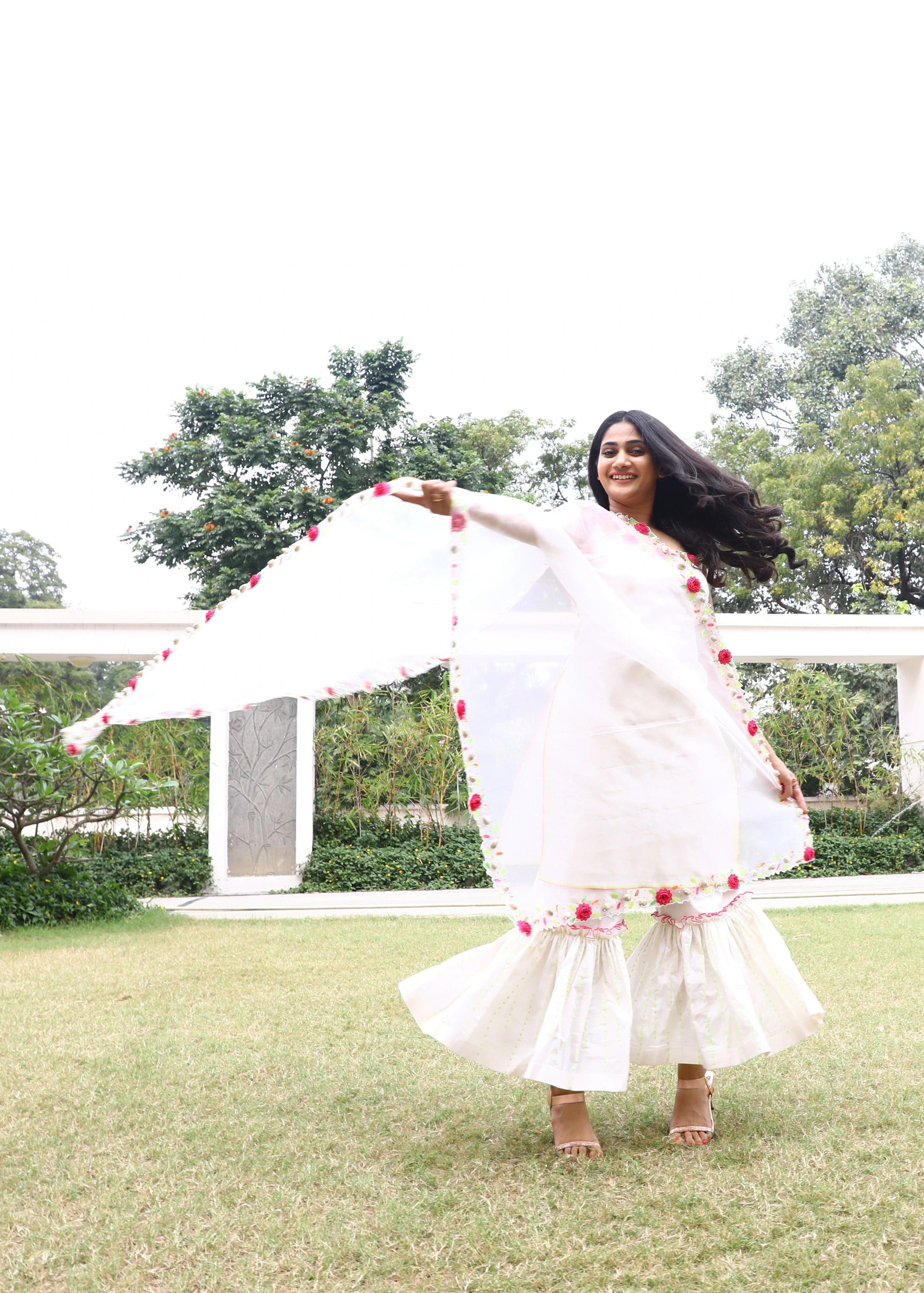 Actor and Influencer Losliya Mariyanesan twirling in a gharara set handcrafted with handmade 3D Flowers, pom poms and sea shells. Designed by Archana Karthick