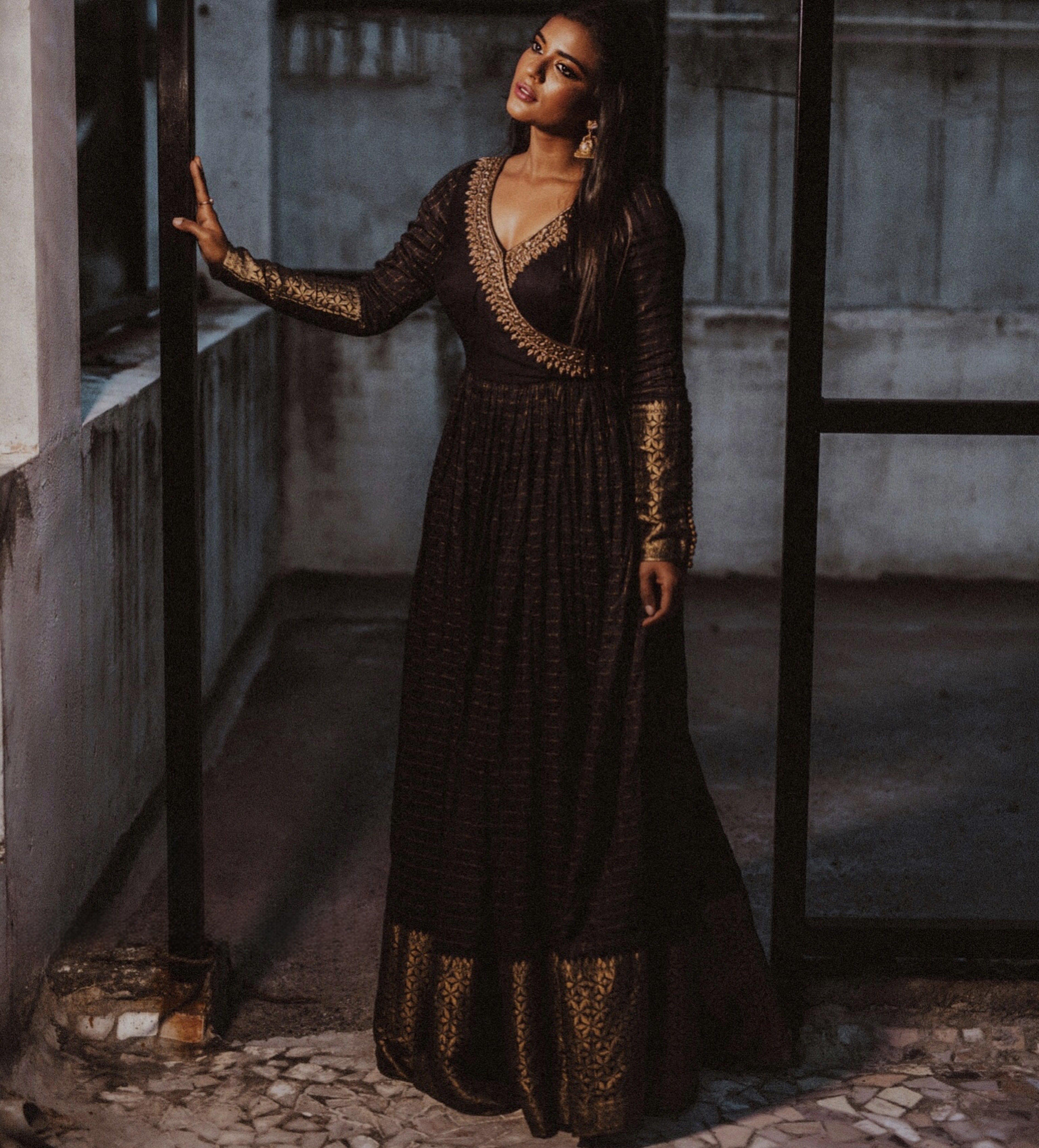 Actress Aishwarya Rajesh in a black silk angrakha anarkali looking away from camera