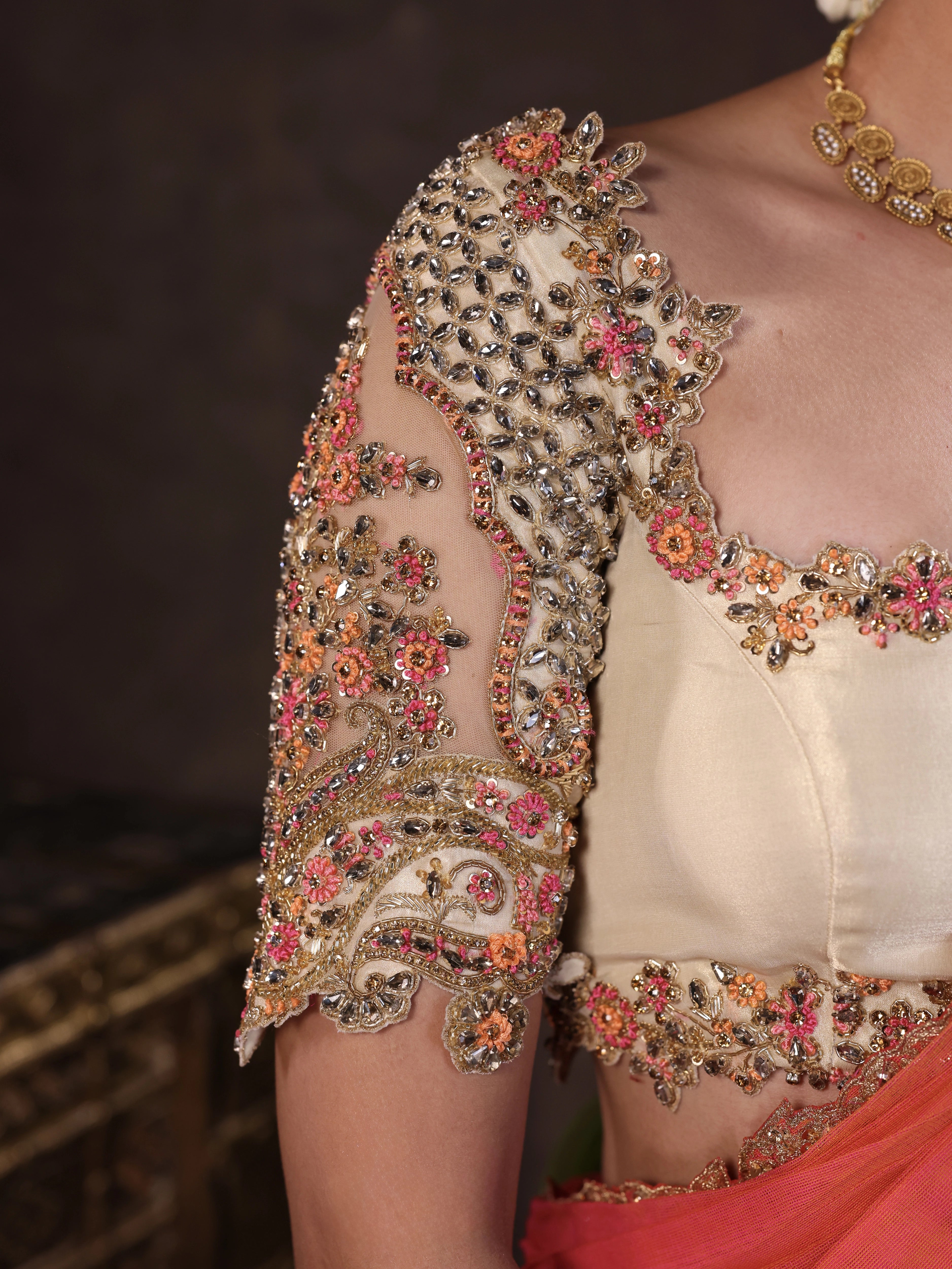 Actress Akshaya Hariharan for a sleeve closeup in an ivory & pink brocade half saree set with tulle sleeves & dupatta. Team Archana Karthick completed the style with purple glass bangles, a ring, jhumkas, nose ring and a maang tikka.