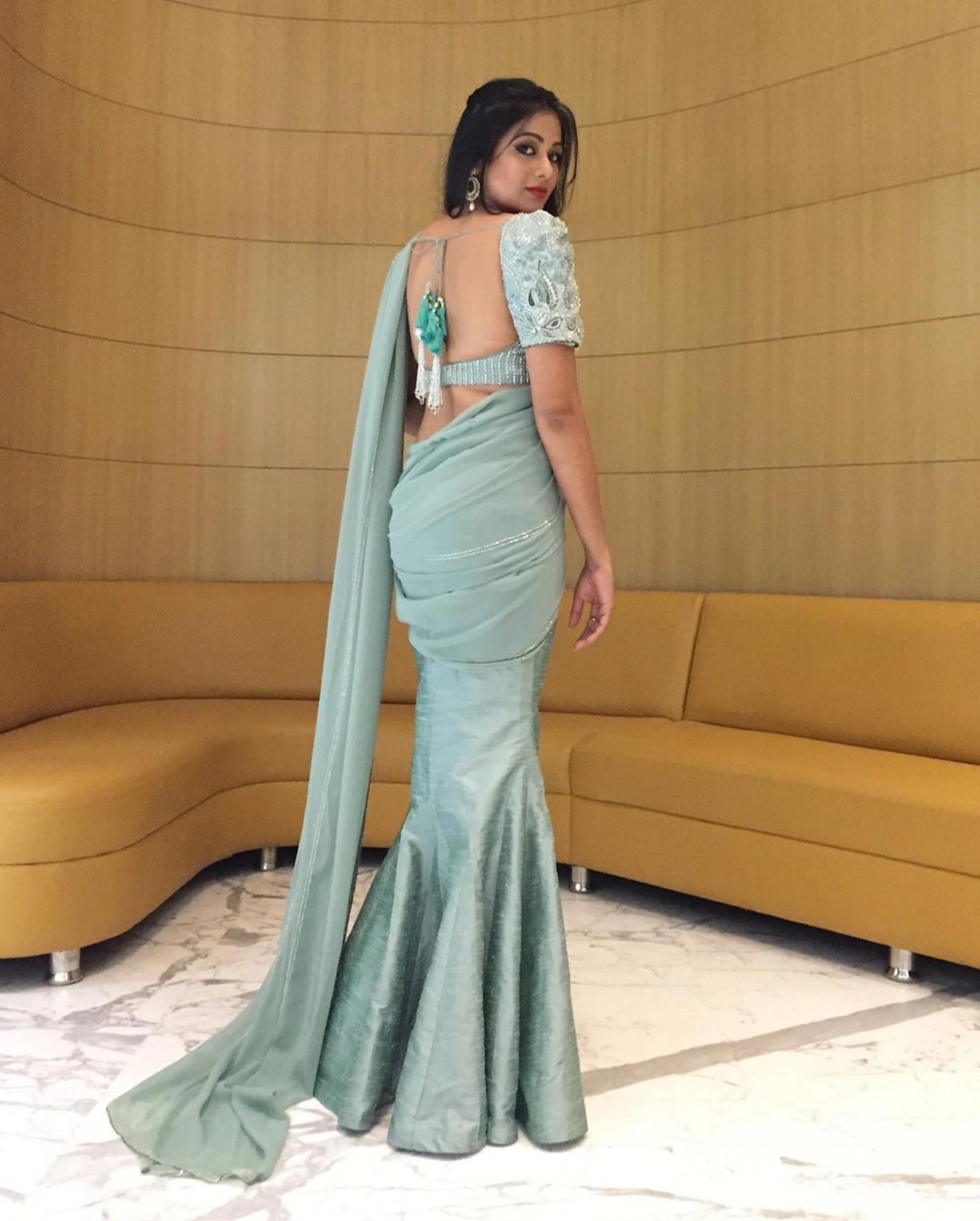 Actress Archita Sahu showcasing back design in a light sea green georgette and raw silk draped mermaid lehenga with puff sleeves handcrafted by Archana Karthick.