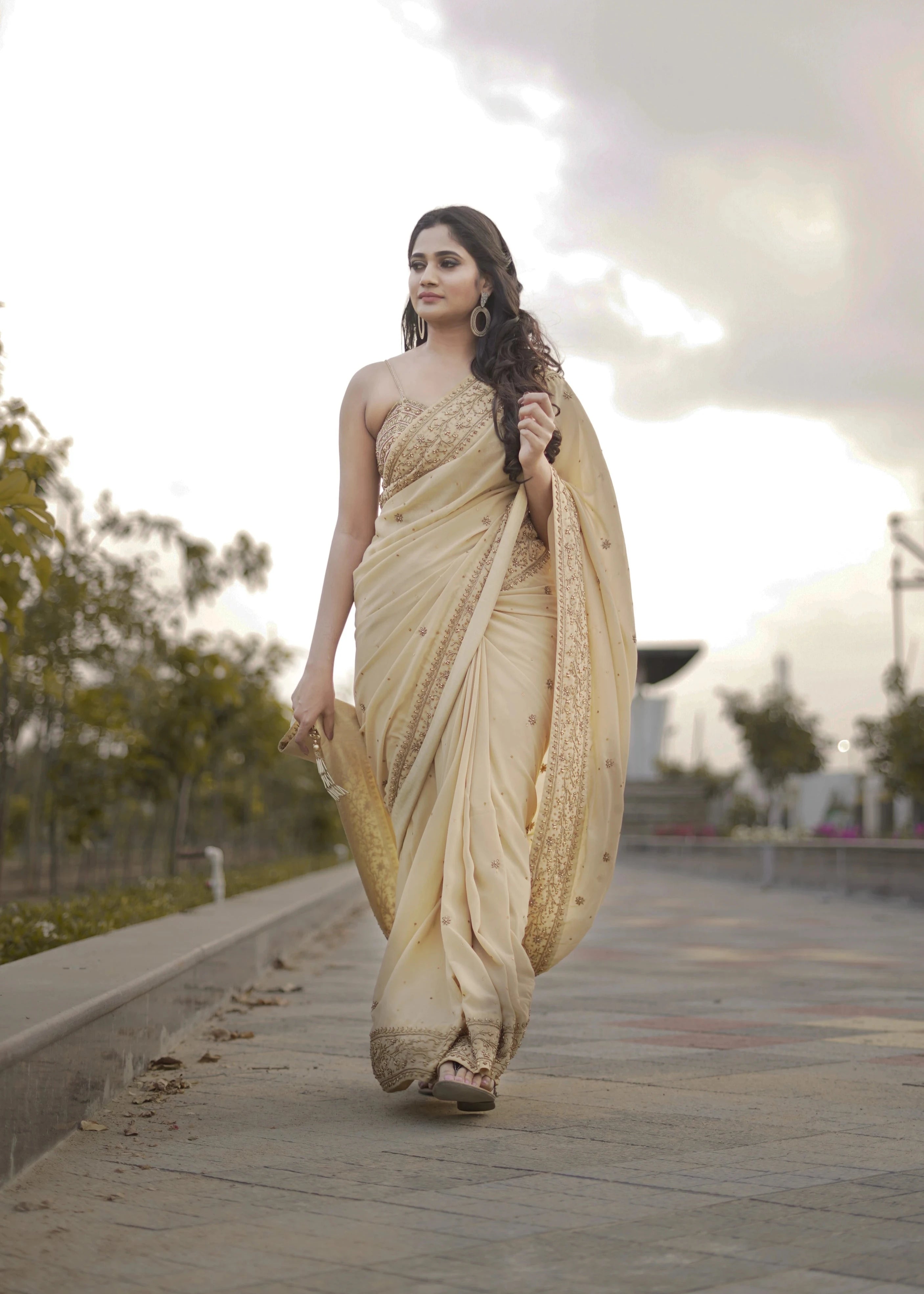 Actress & Bigg Boss fame Losliya in a beige georgette saree paired with a bralette, handcrafted with beads, sequins and pearls by team Archana Karthick.