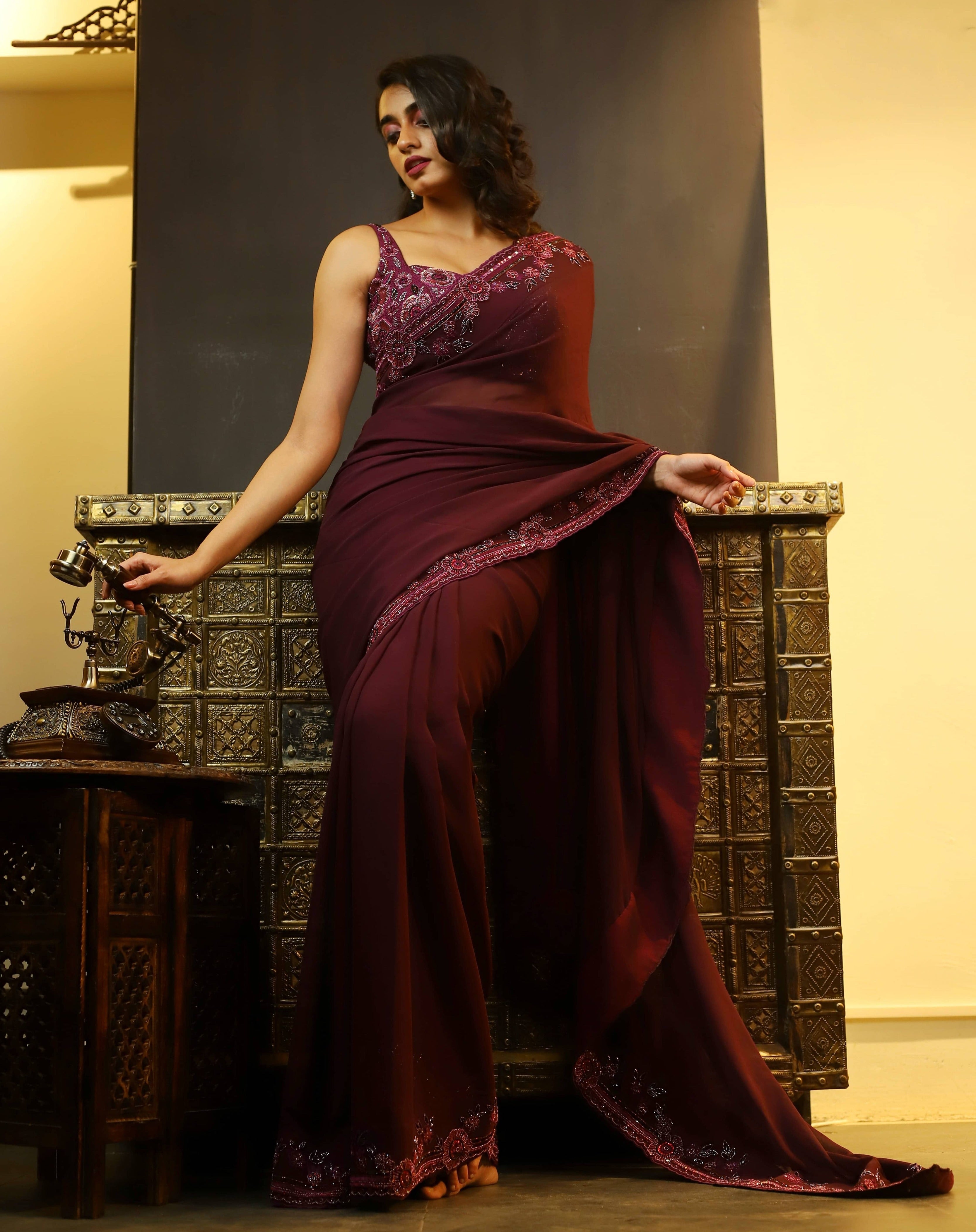 Actress Cherukuri Maanasa Choudhary who acted in the movie Lucky Baskhar with Dulquer Salmaan is seen here in an eggplant aubergine colored georgette saree and embellished blouse. Full front pose.