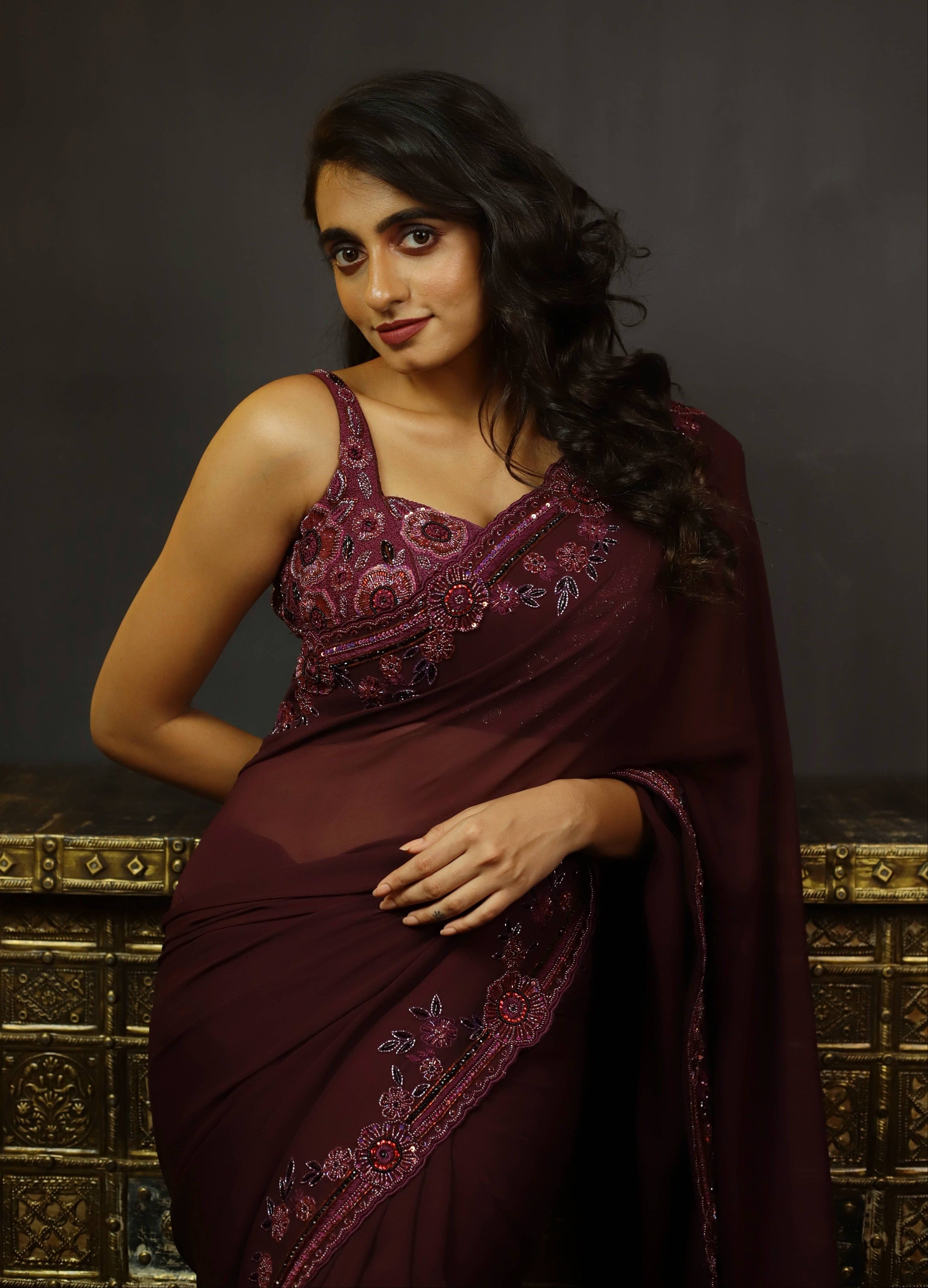 Actress Cherukuri Maanasa Choudhary who acted in the movie Lucky Baskhar with Dulquer Salmaan is seen here in an eggplant aubergine colored georgette saree and embellished blouse. blouse front design.