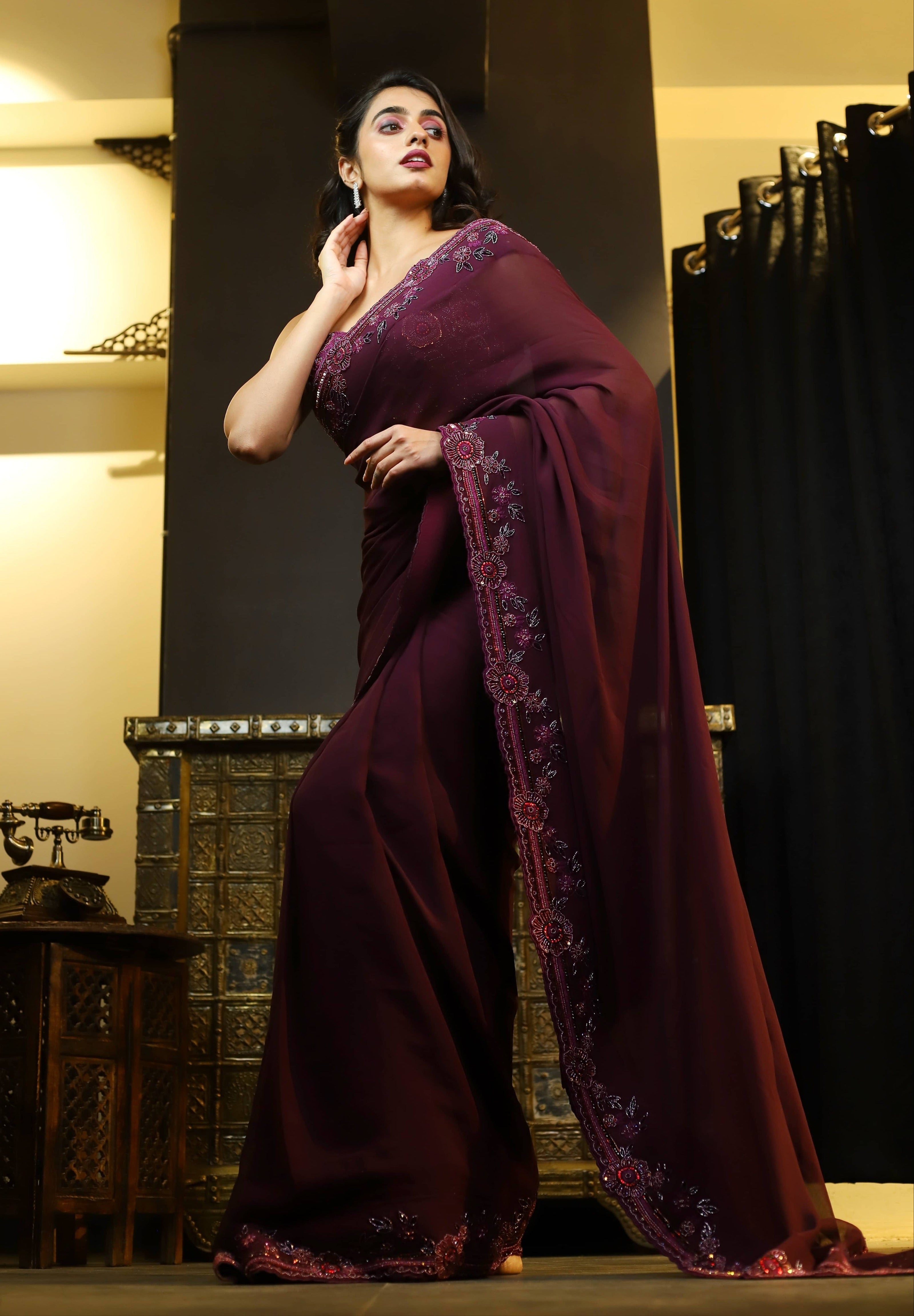 Actress Cherukuri Maanasa Choudhary who acted in the movie Lucky Baskhar with Dulquer Salmaan is seen here in an eggplant aubergine colored georgette saree and embellished blouse. pallu border design