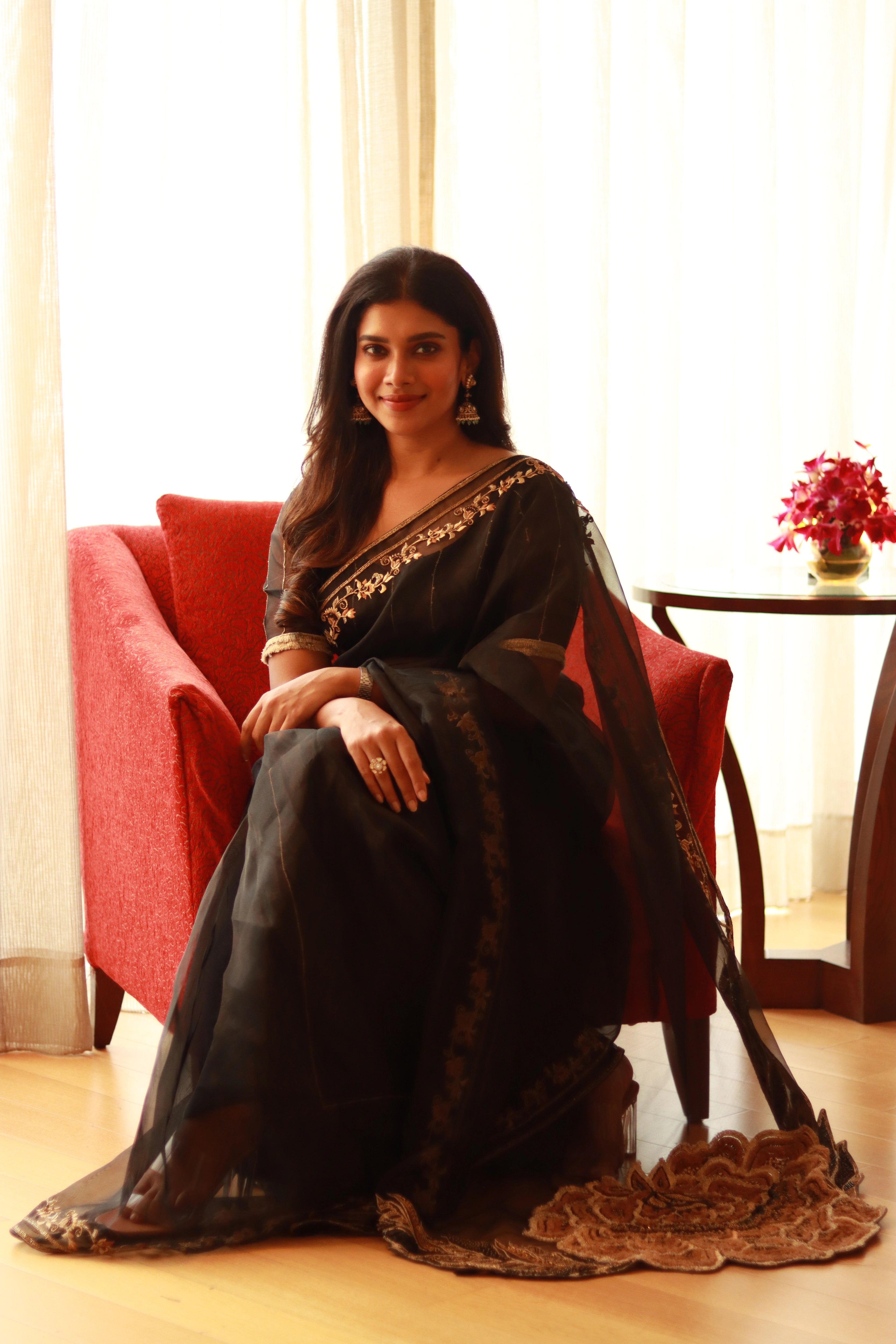 Actress Dushara Vijayan in a black organza saree, intricately handcrafted with cutdana, zari, beads, sequins and resham by team Archana Karthick.