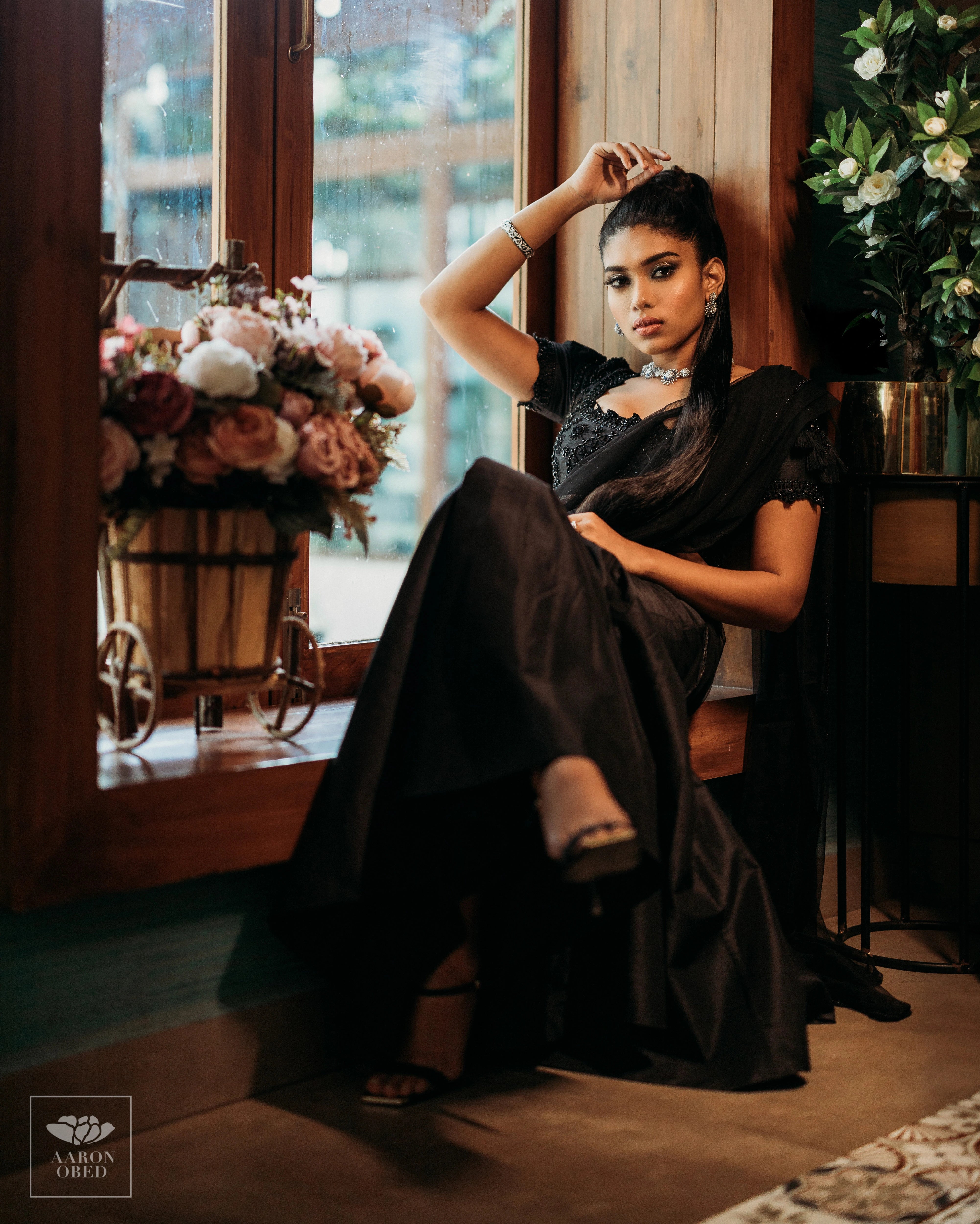 Actress Dushara Vijayan posing for photoshoot in a black tulle and raw silk draped mermaid lehenga, intricately handcrafted with beads, sequins and resham by team Archana Karthick.