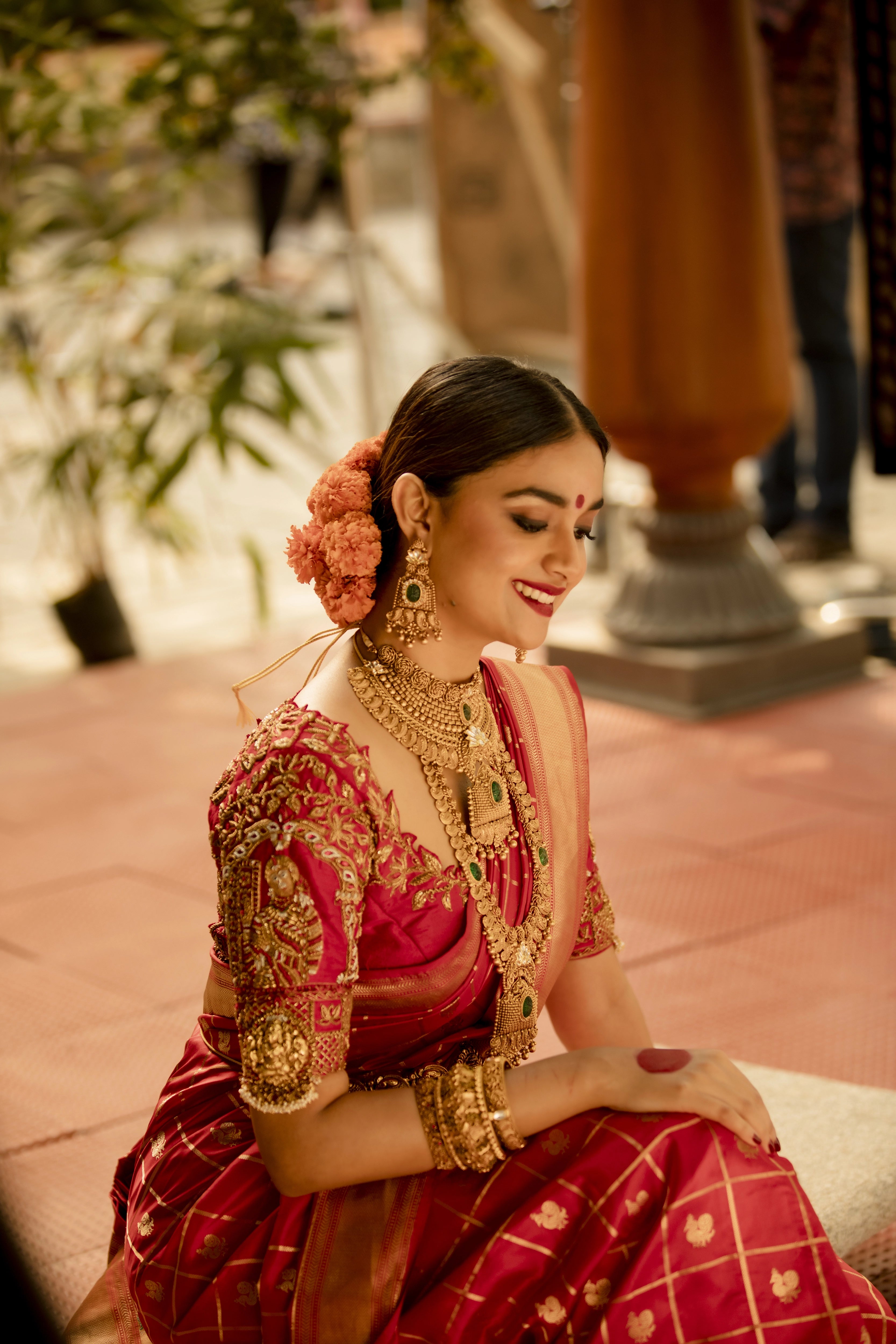 Actress Keerthy Suresh posing in a red raw silk palanquin concept blouse handcrafted by team Archana Karthick.