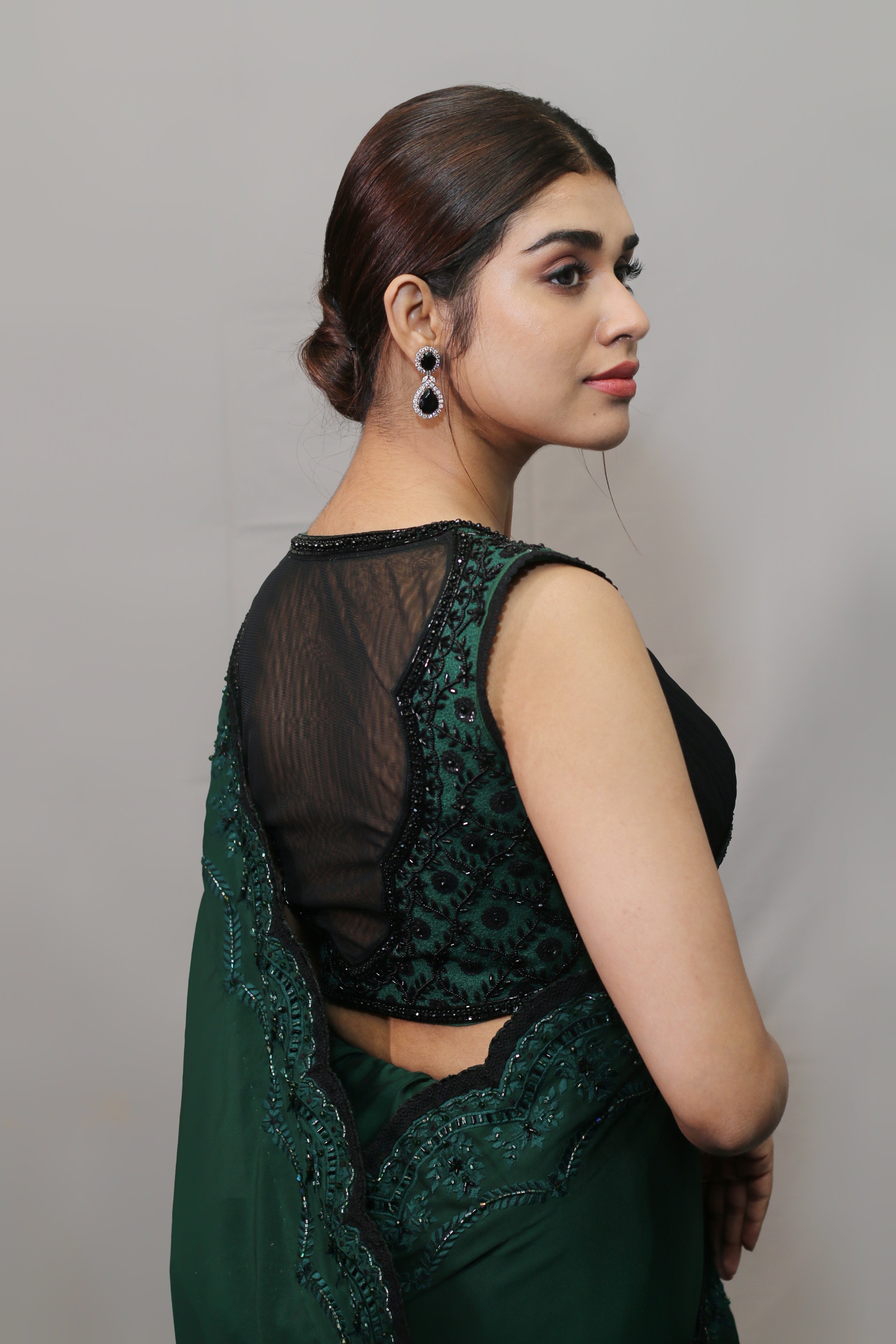 Actress Meenakshi Govindarajan in bottle green satin georgette saree set showcasing back blouse design