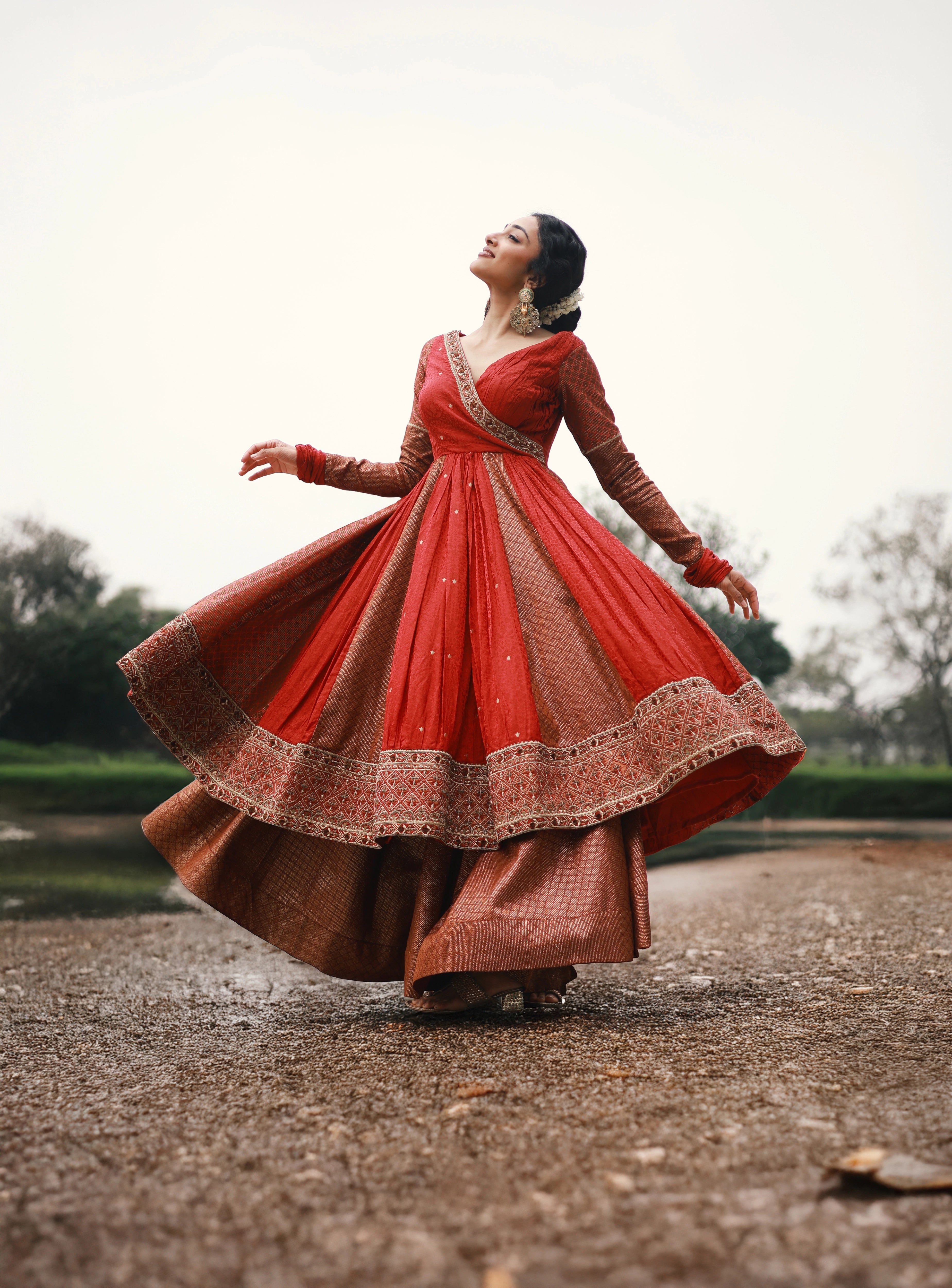 Actress Preity Mukhundhan in a red-orange banarasi tissue and silk angrakha anarkali with a sharara pant and tissue dupatta by team Archana Karthick.