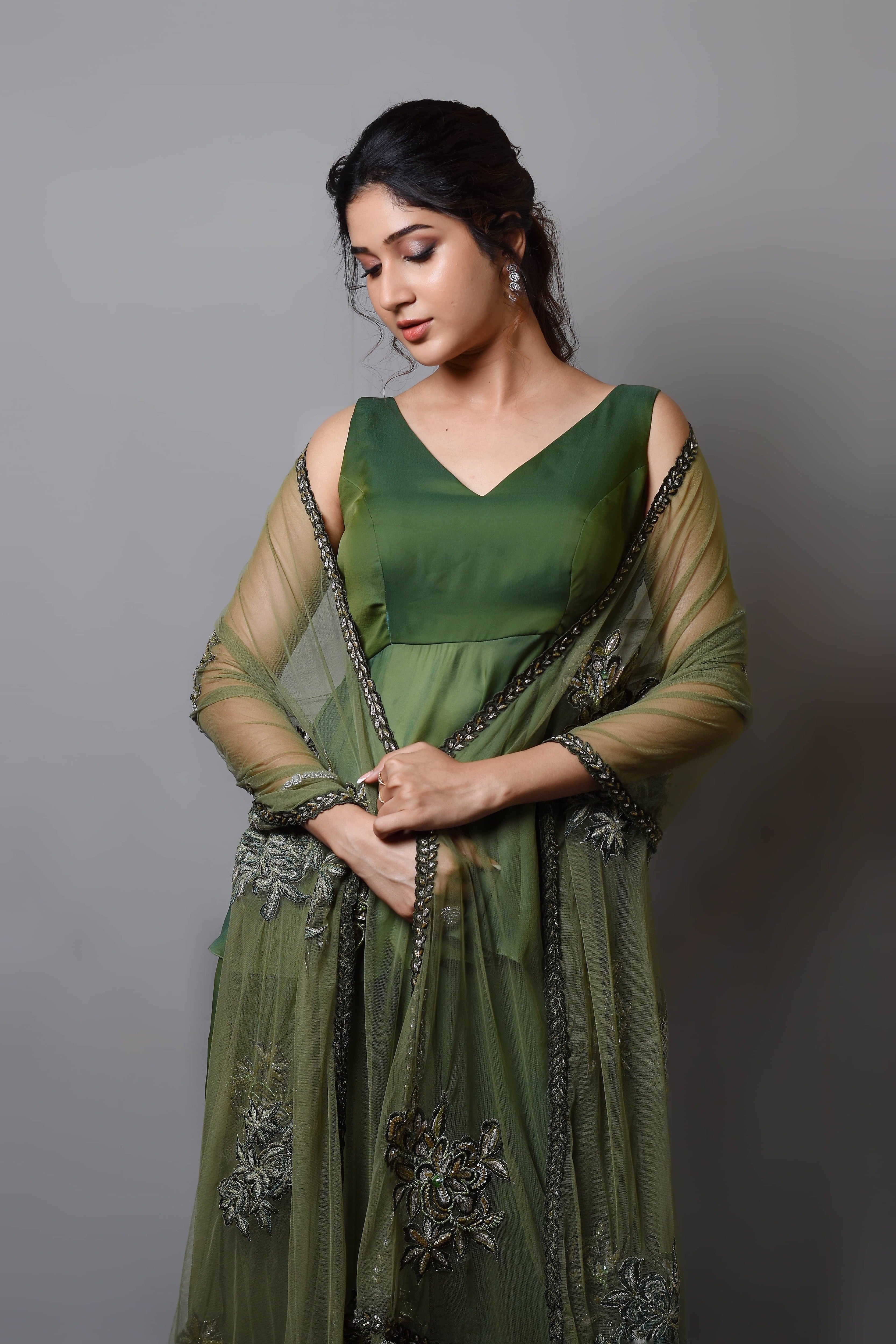 Actress Rabiya Khatoon in a green satin georgette peplum sharara palazzo set with embellished dupatta. dupatta wrapped around her.