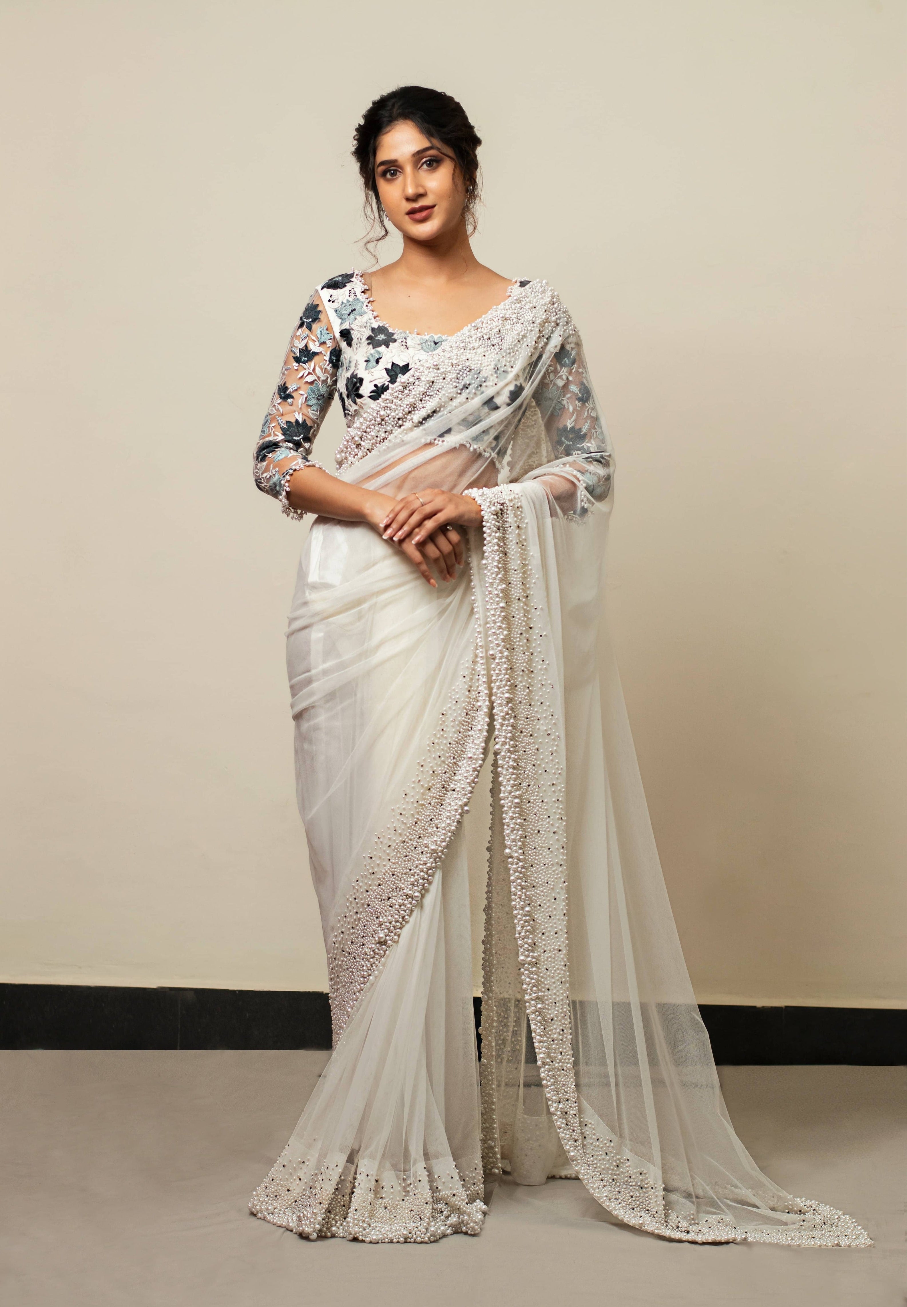 Actress Rabiya Khatoon in white net saree with pearl embellished border and blue florals in resham full sleeved blouse.