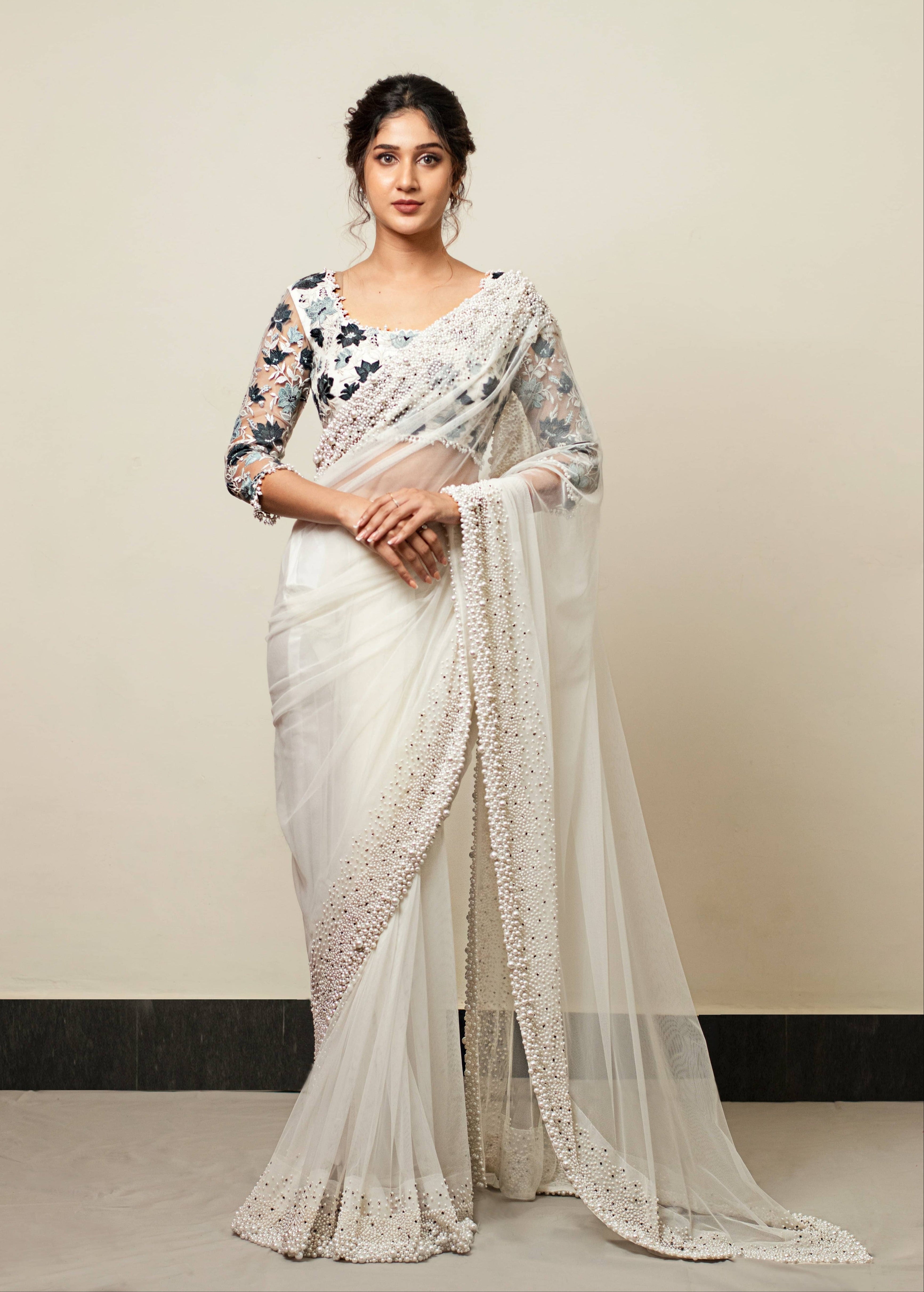 Actress Rabiya Khatoon in white net saree with pearl embellished border and blue florals in resham full sleeved blouse. Full front profile saree and blouse.