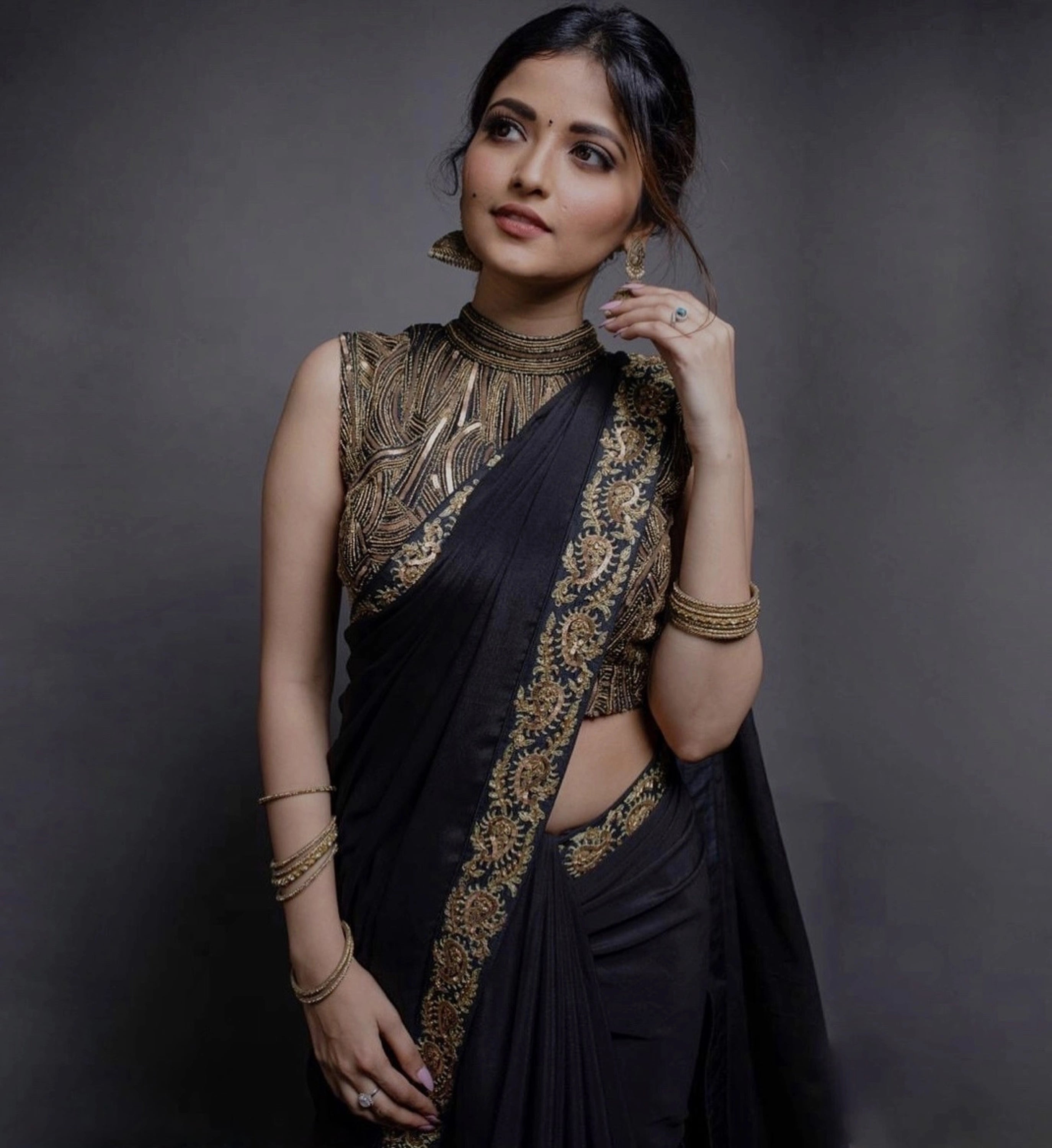 Actress Shirin Kanchwala looks away  in a crepe silk black saree intricately handcrafted with zardozi, sequins and dori work by team Archana Karthick.
