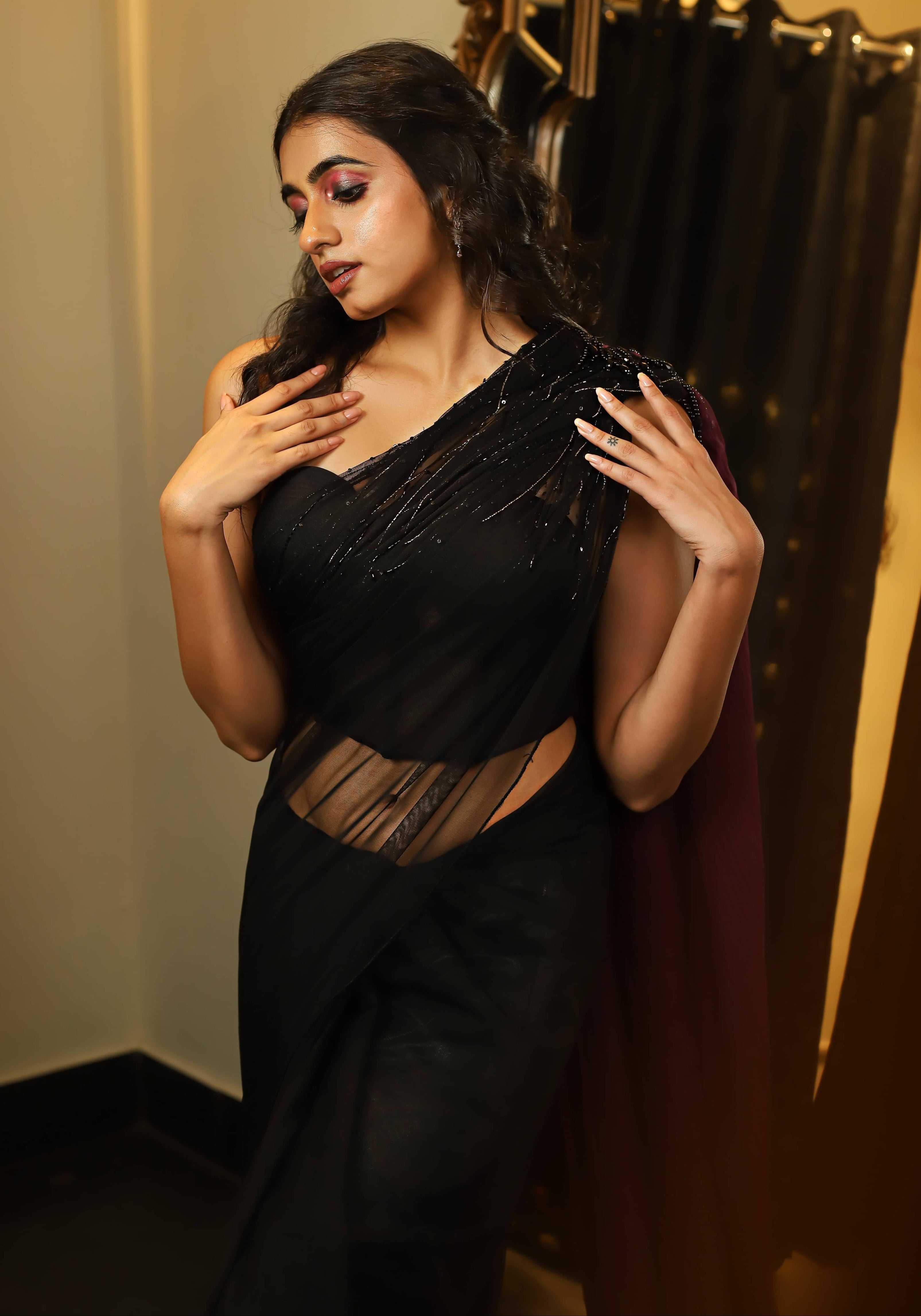 Actress and Model Cherukuri Maanasa Choudhary who acted in Lucky Baskhar in a black aubergine saree and bralette set with cut dana detailings. front blouse and pallu detailing.