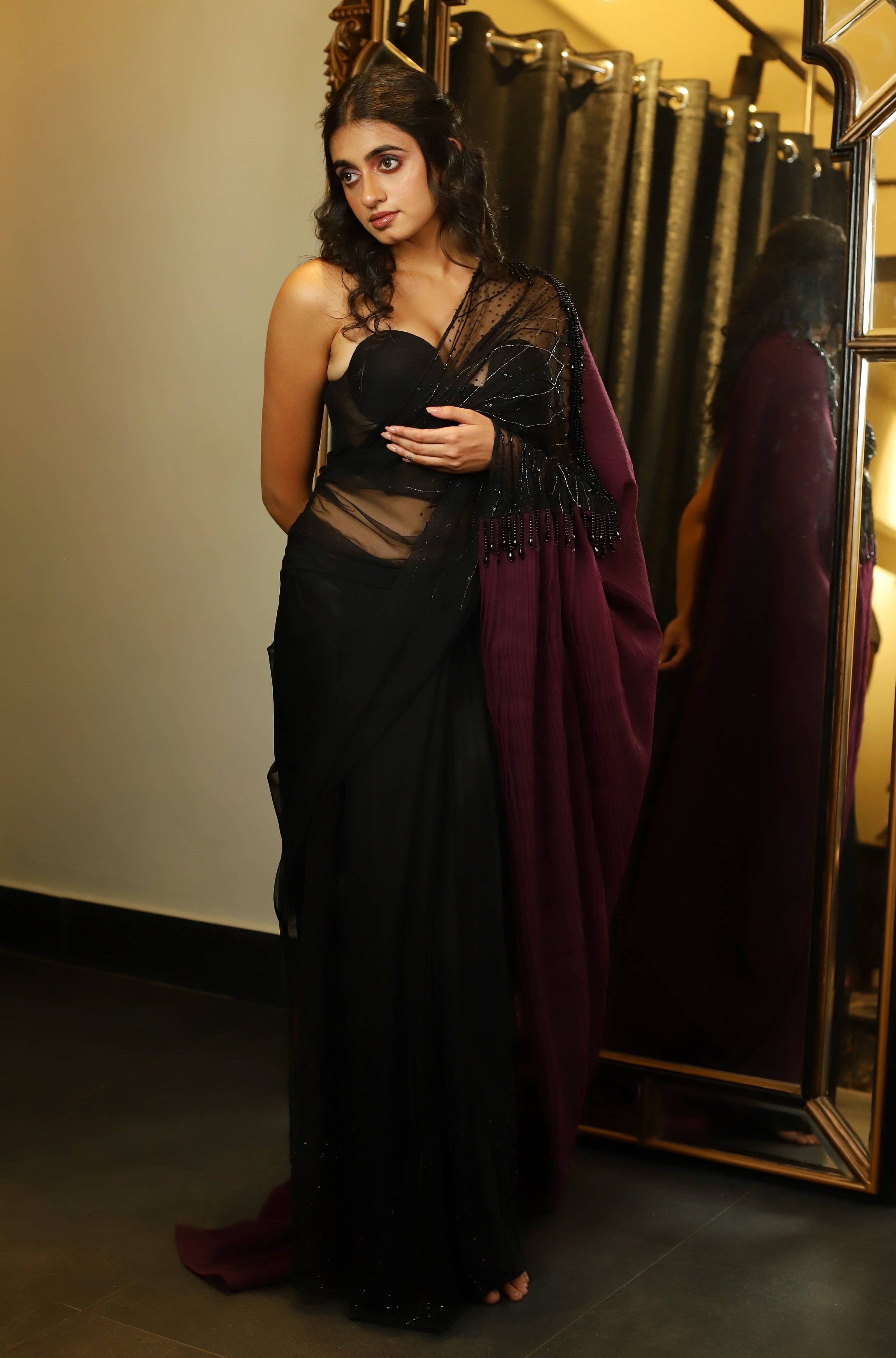 Actress and Model Cherukuri Maanasa Choudhary who acted in Lucky Baskhar in a black aubergine saree and bralette set with cut dana detailings. full front blouse and saree detailing.