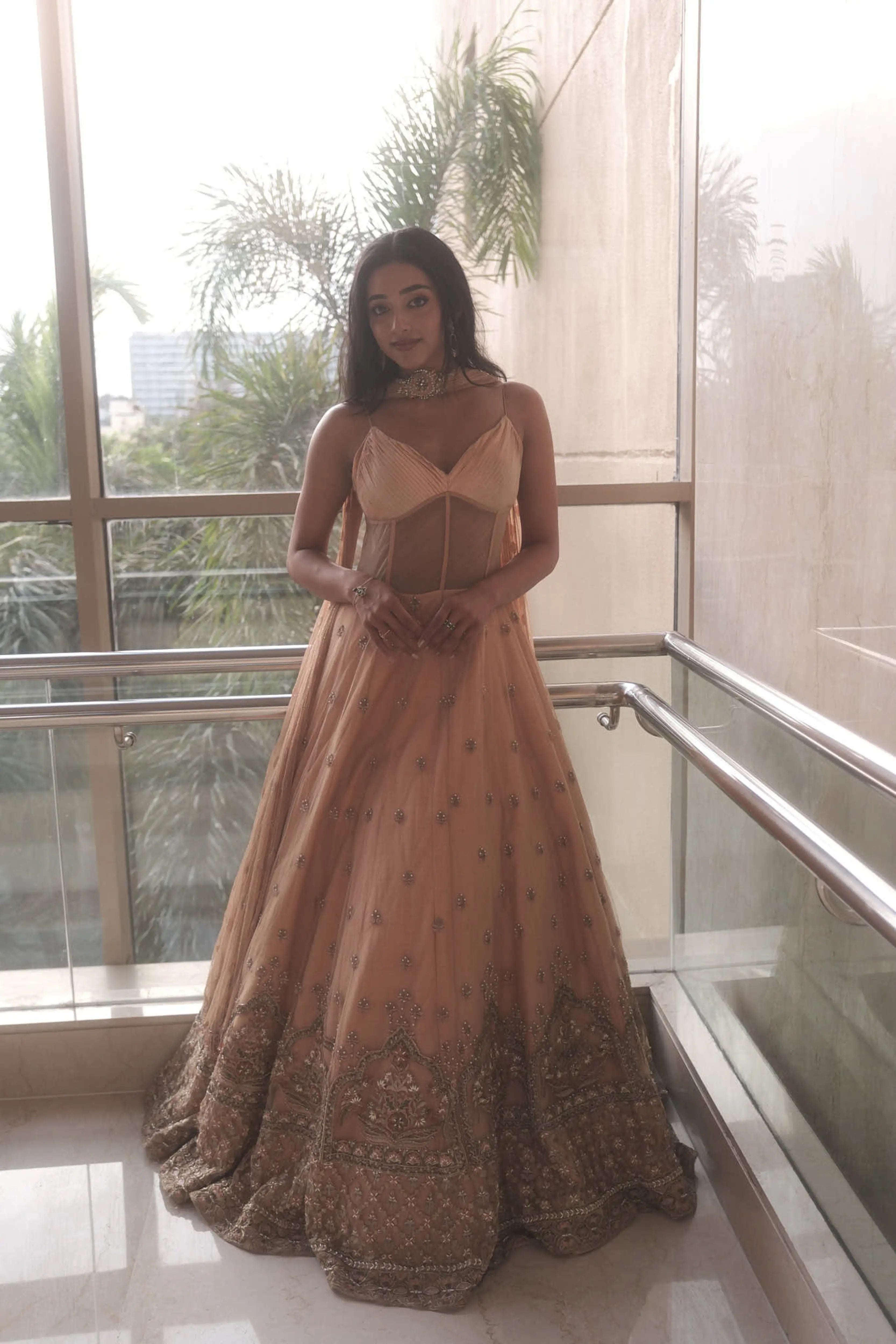 Actress & dancer Preity Mukhundhan in a peach corset gown with draped dupatta attached at the neck, intricately handcrafted by team Archana Karthick.