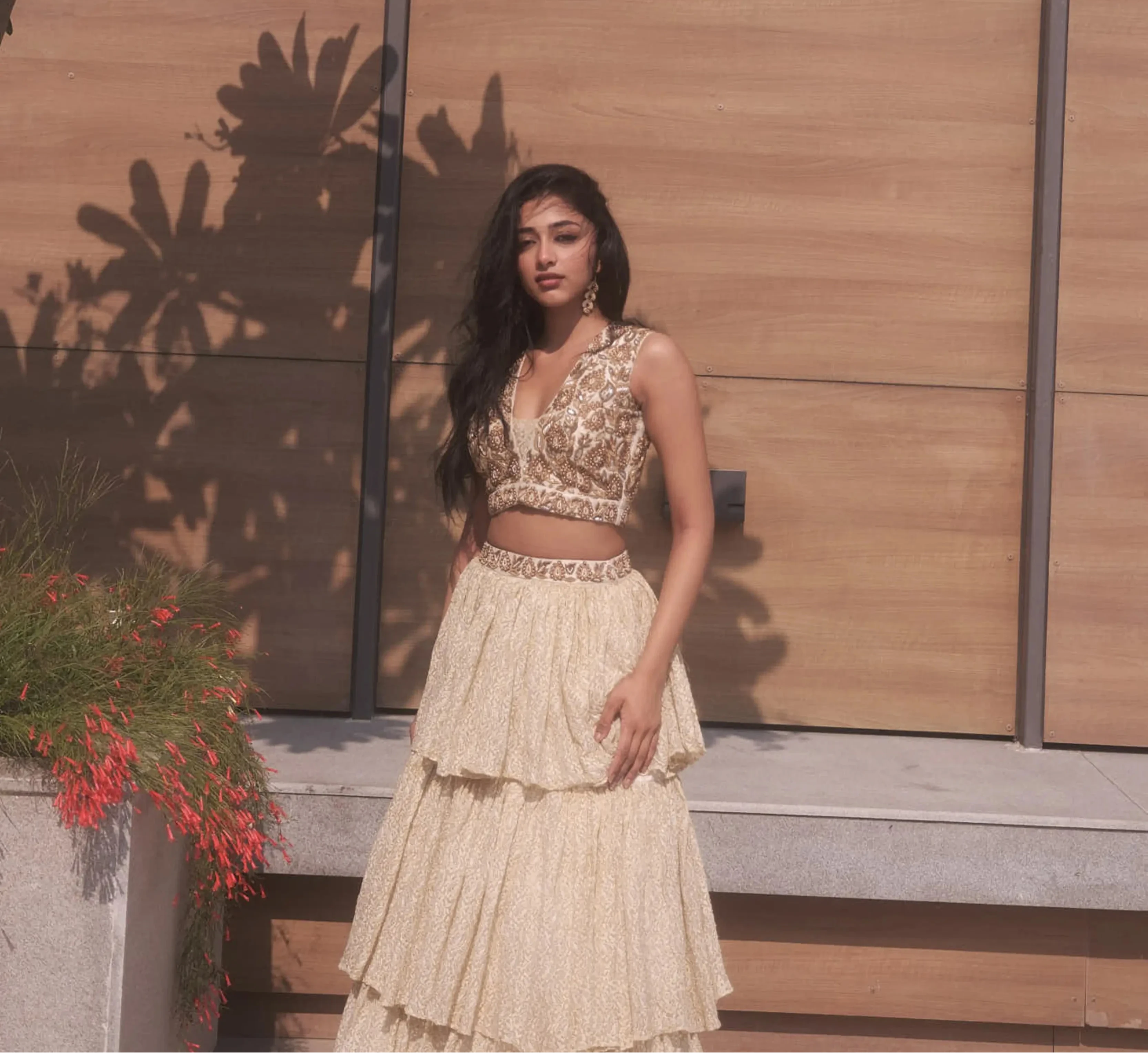 Actress & dancer Preity Mukhundhan posing in a plunge neck raw silk ivory crop-top bralette and layered skirt in brasso fabric with self work by team Archana Karthick.