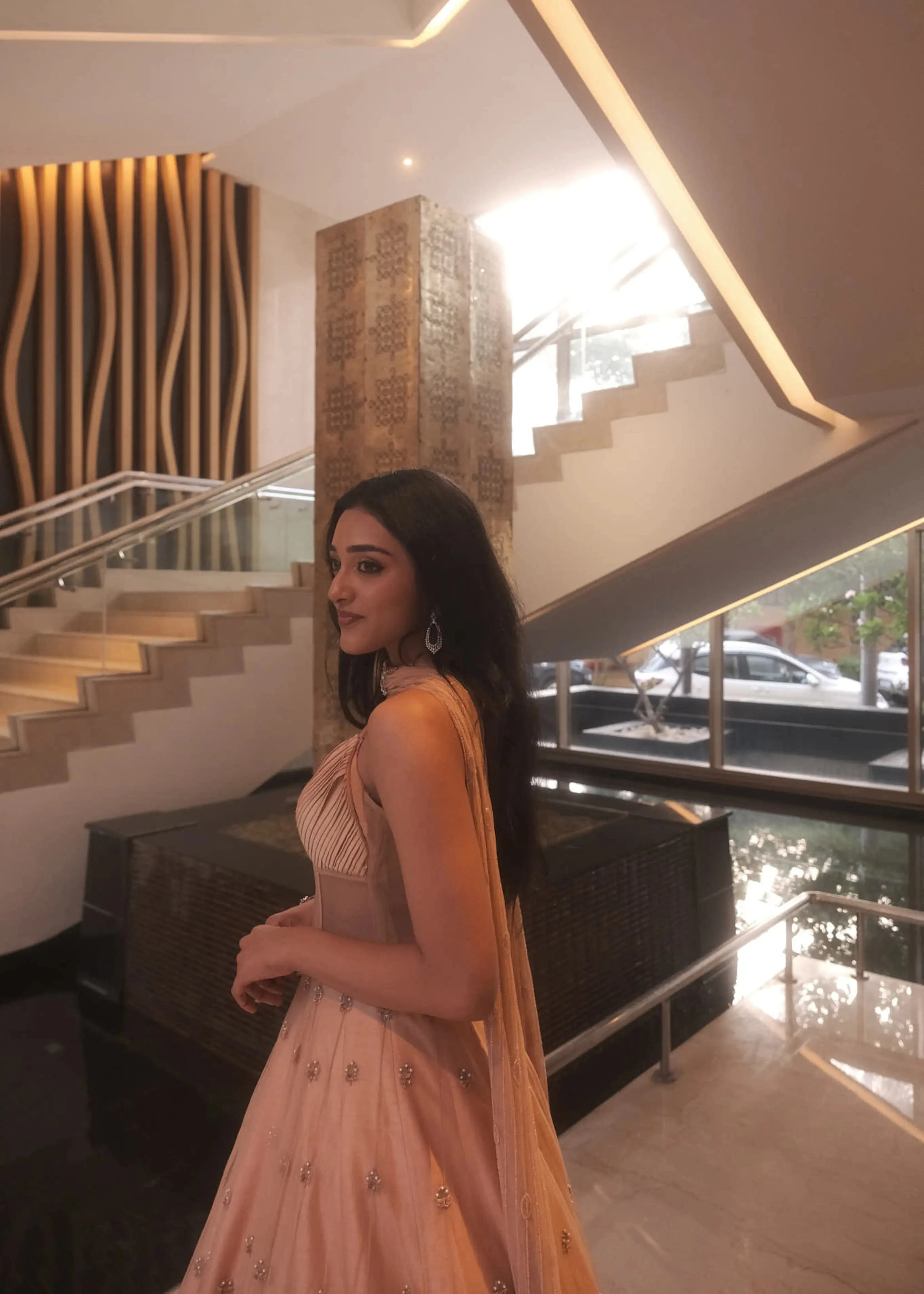 Actress & dancer Preity Mukhundhan smiling in a peach corset gown with draped dupatta attached at the neck, intricately handcrafted by team Archana Karthick.