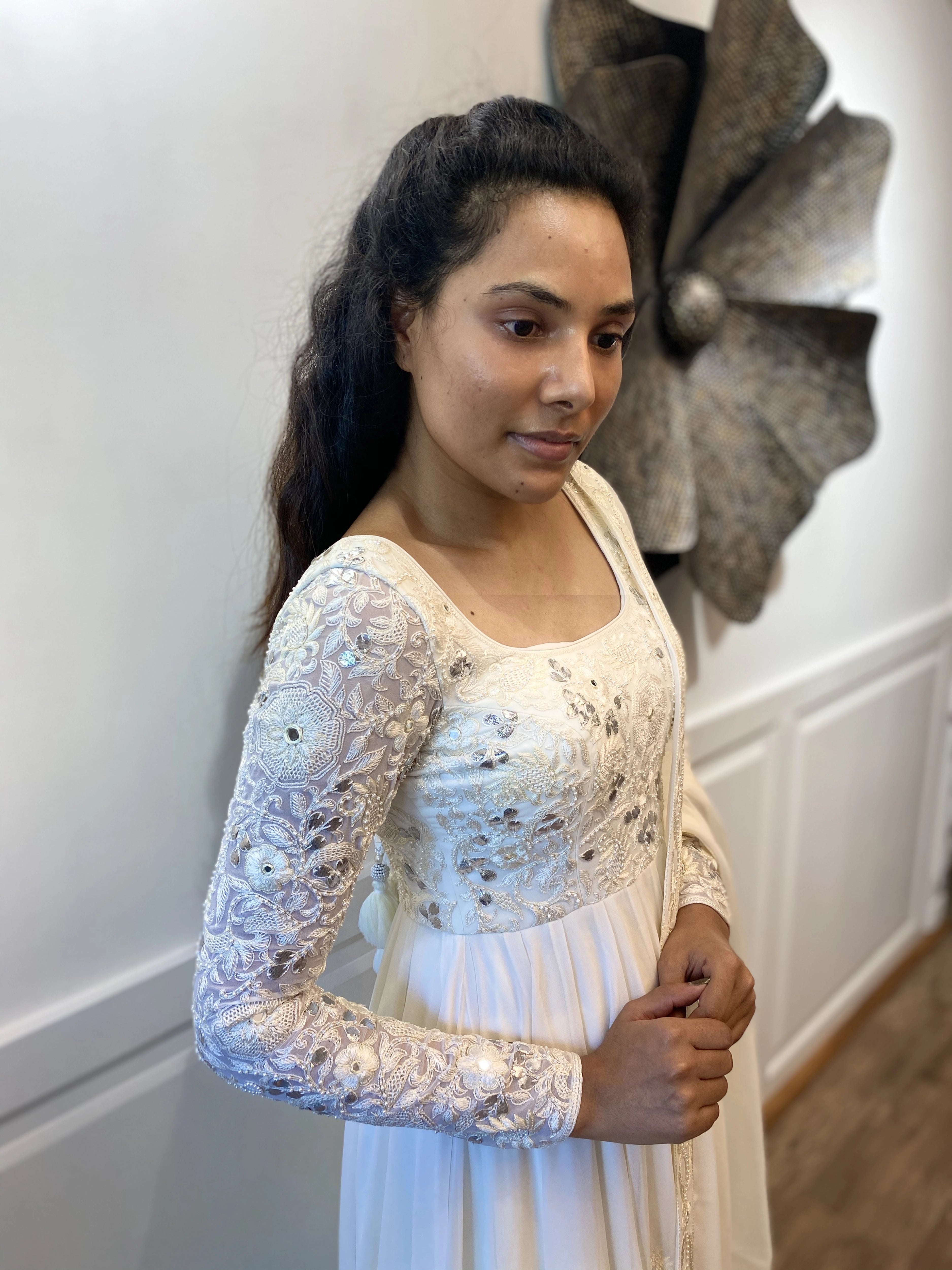 Arshitha from Bangalore posing in a white georgette anarkali, intricately handcrafted with gotapati, resham (chikanakri work) by team Archana Karthick.