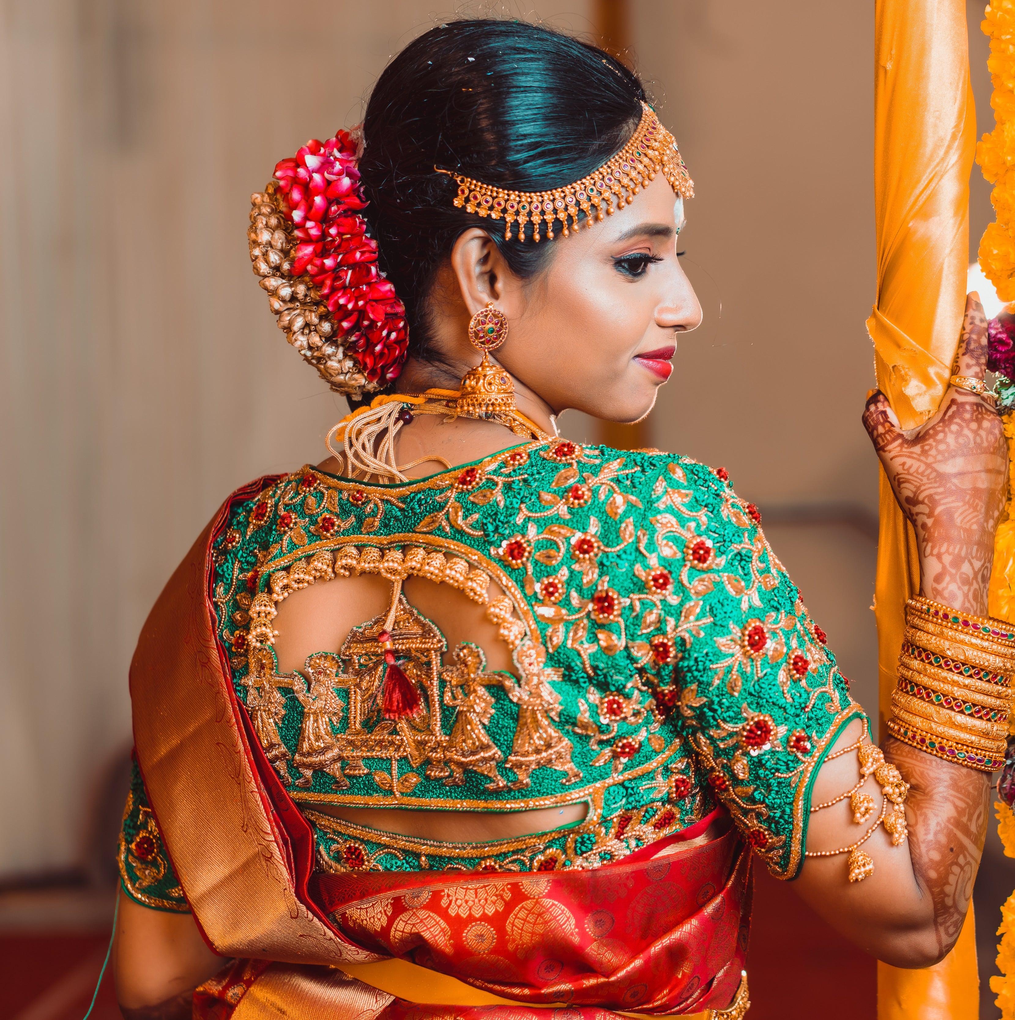 Bride Abhinaya in a handcrafted green raw silk blouse designed by Archana Karthick. Bride is posing for back blouse design of the palanquin bride design or doli design to be captured.