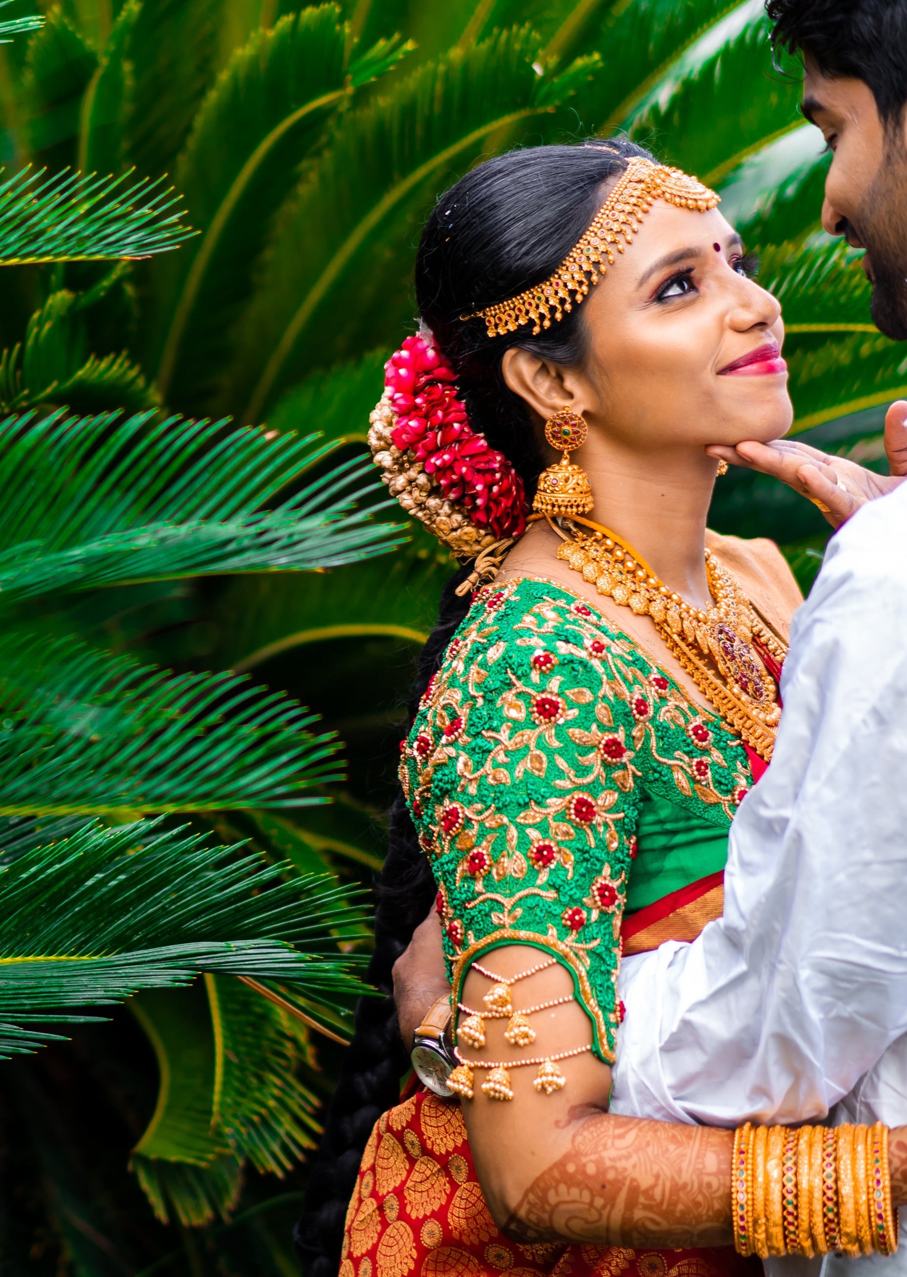 Bride Abhinaya in a handcrafted green raw silk blouse designed by Archana Karthick. Bride is posing in an embrace