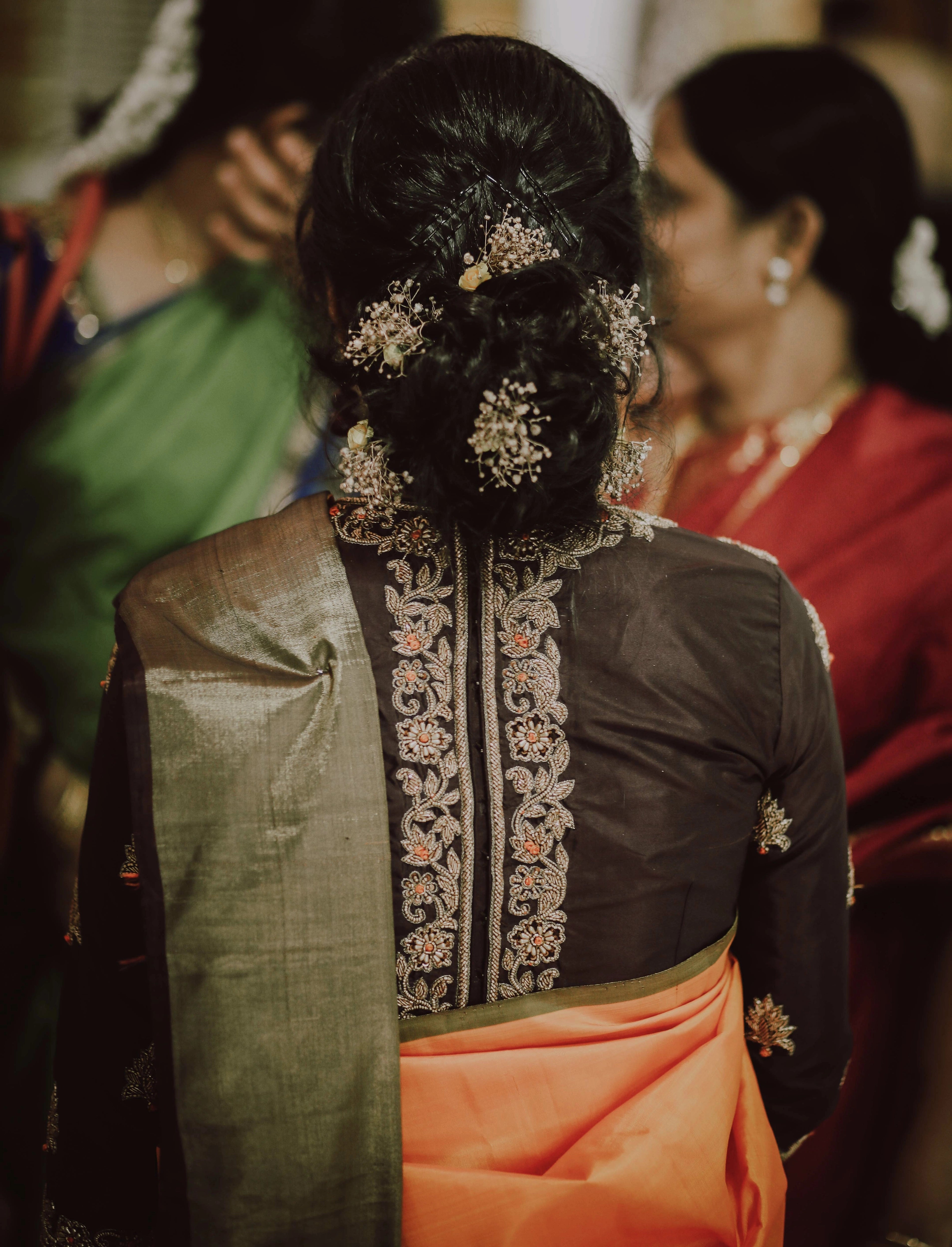 Bride Akshaya from USA showcasing back design in a brown silk blouse handcrafted intricately with beads, cutdana and resham by team Archana Karthick.