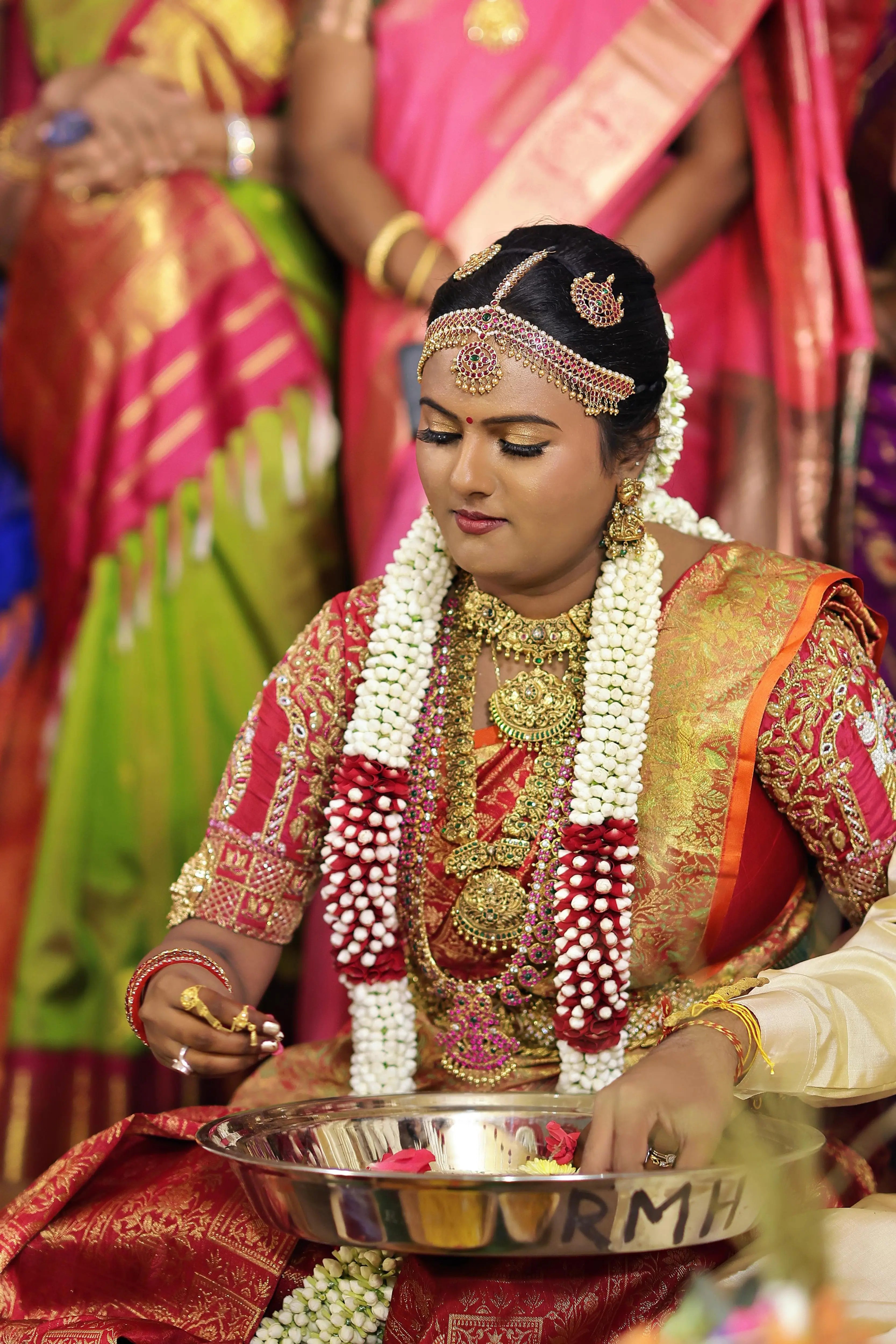 Bride Amirtha in a red silk blouse by team Archana Karthick.