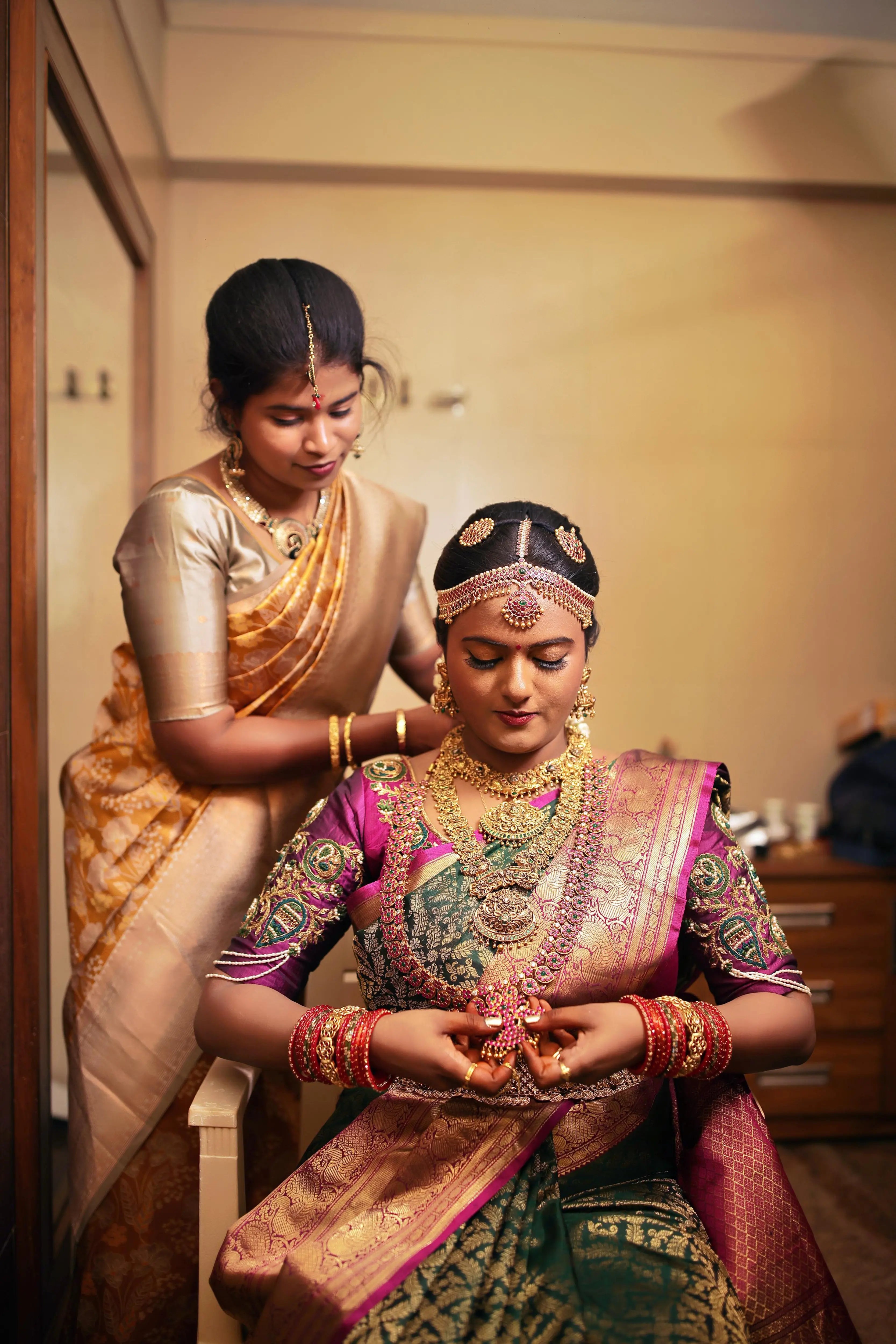 Bride Amirtha posing in a dark magenta silk blouse by team Archana Karthick.