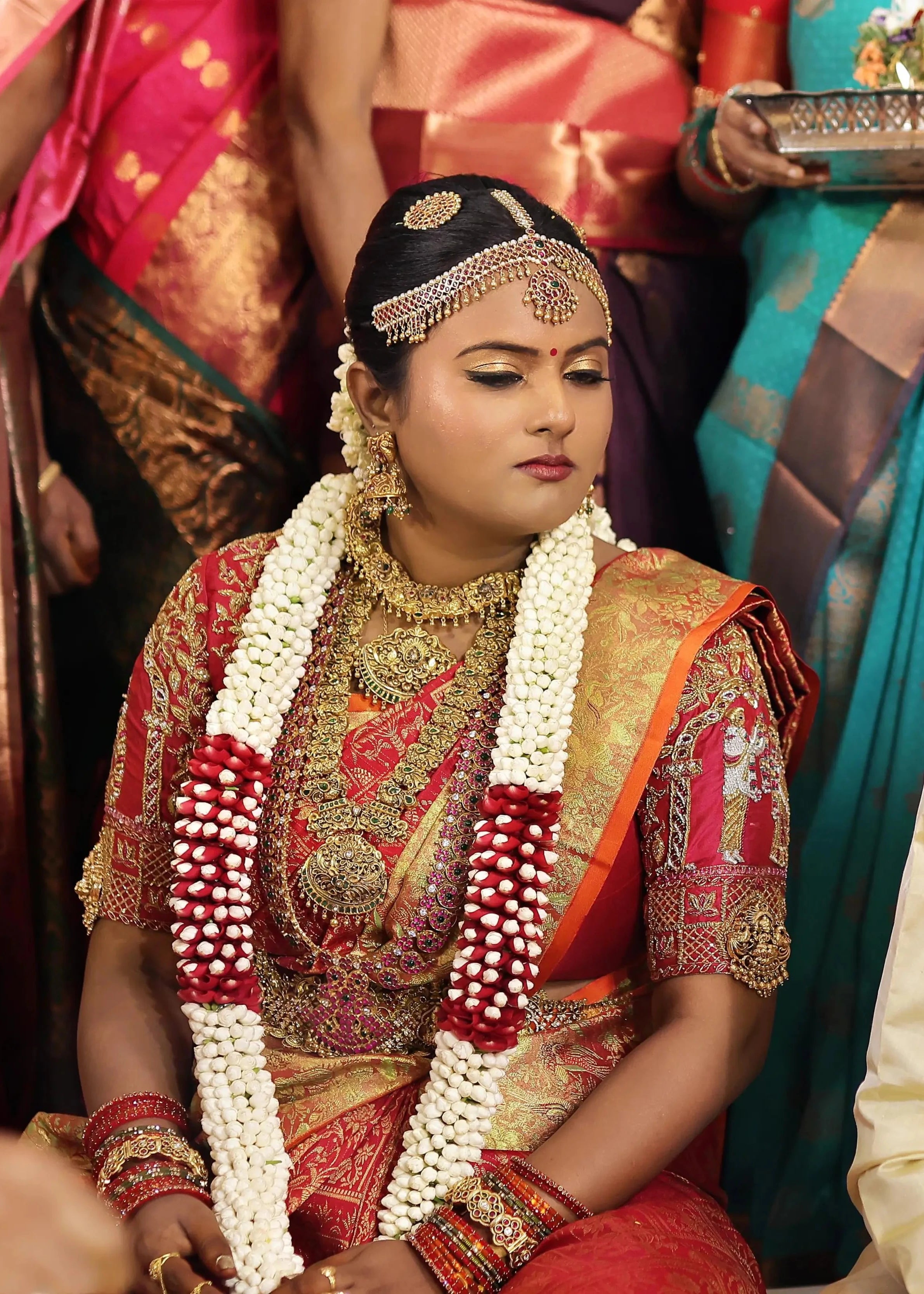 Bride Amirtha posing in a red silk blouse by team Archana Karthick.