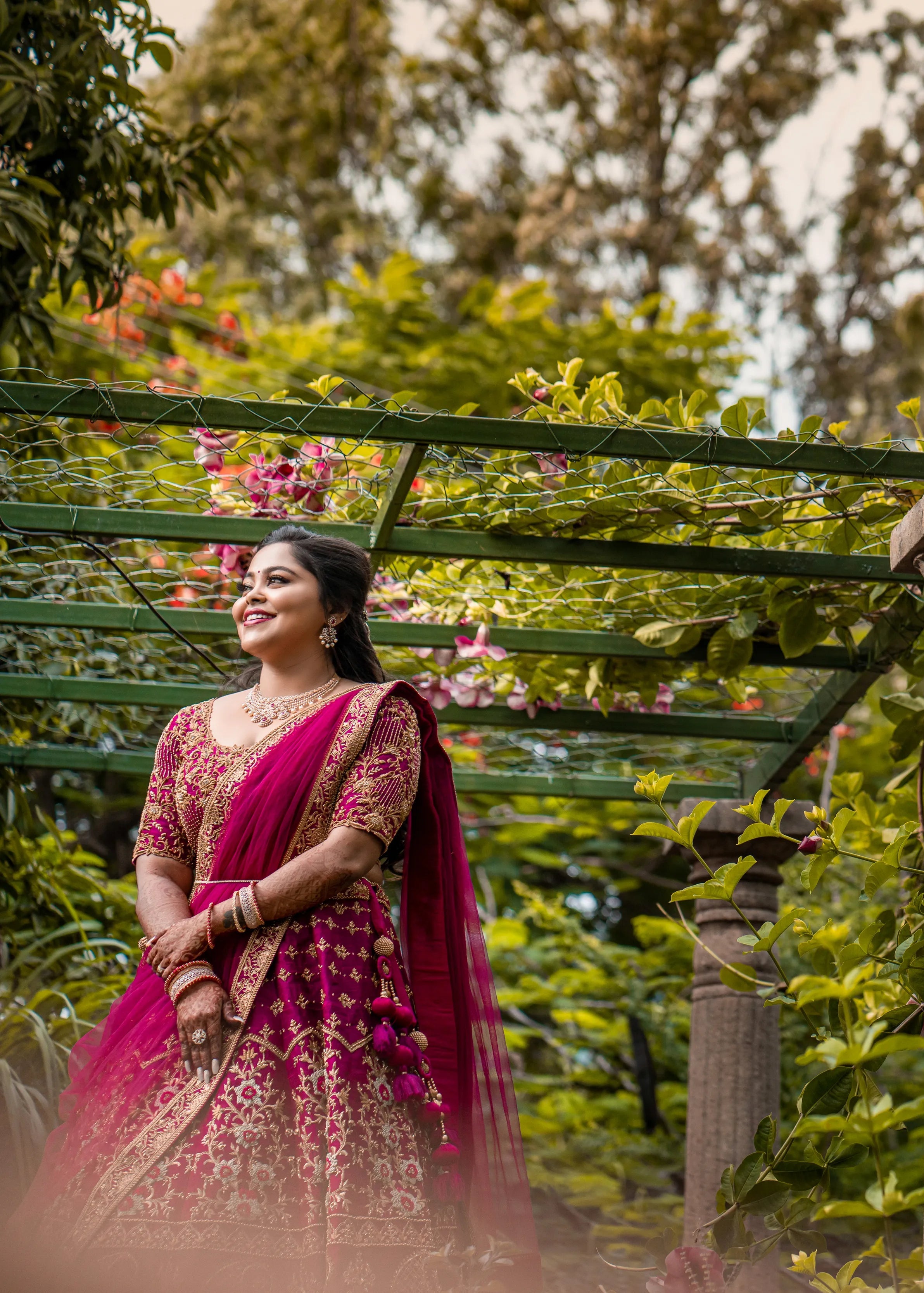 Bride Anjana from coimbatore looking far in a magenta red raw silk bridal lehenga designed by Archana Kartrhick.