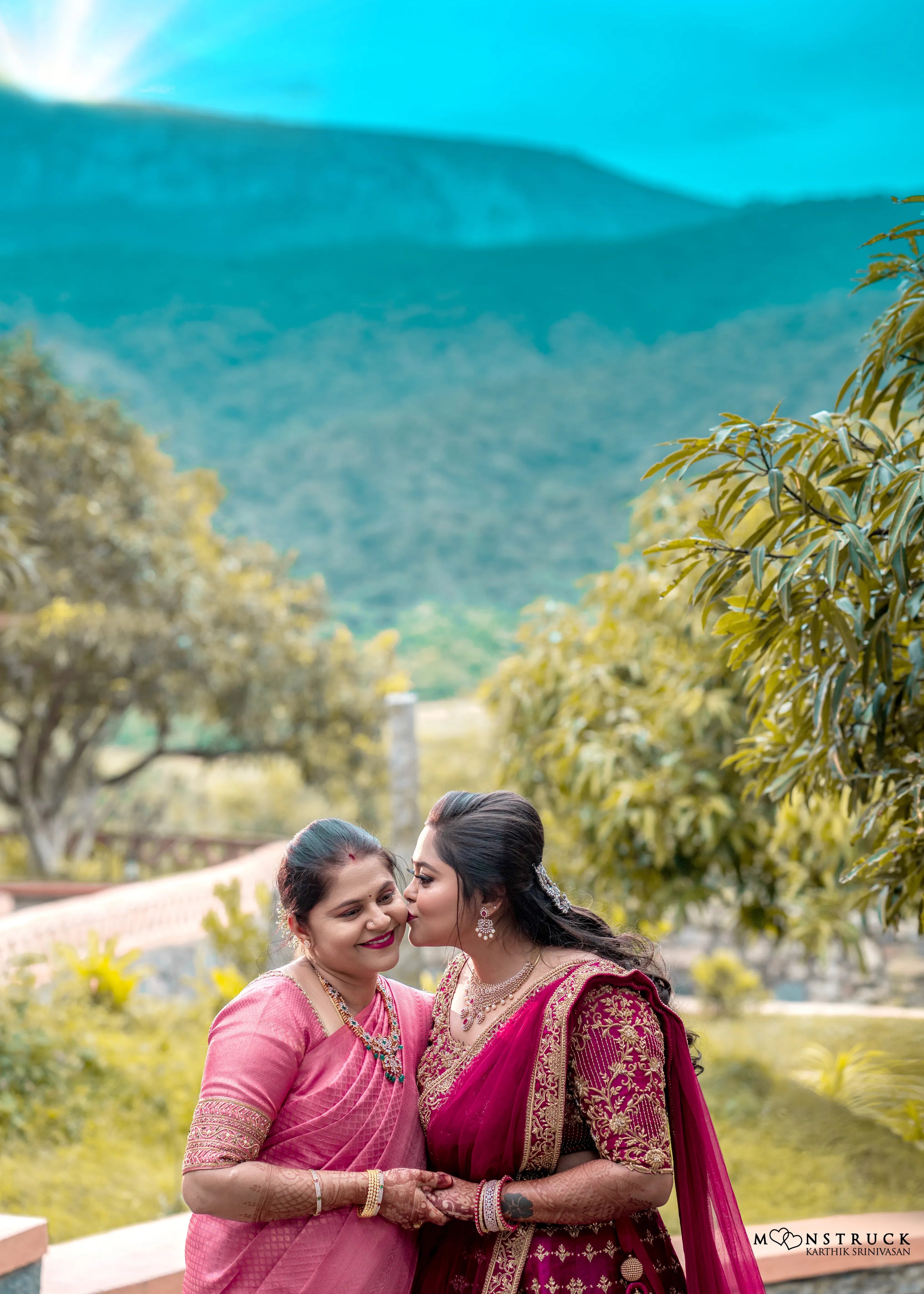 Bride Anjana from coimbatore posing with mother in a magenta red raw silk bridal lehenga designed by Archana Kartrhick.