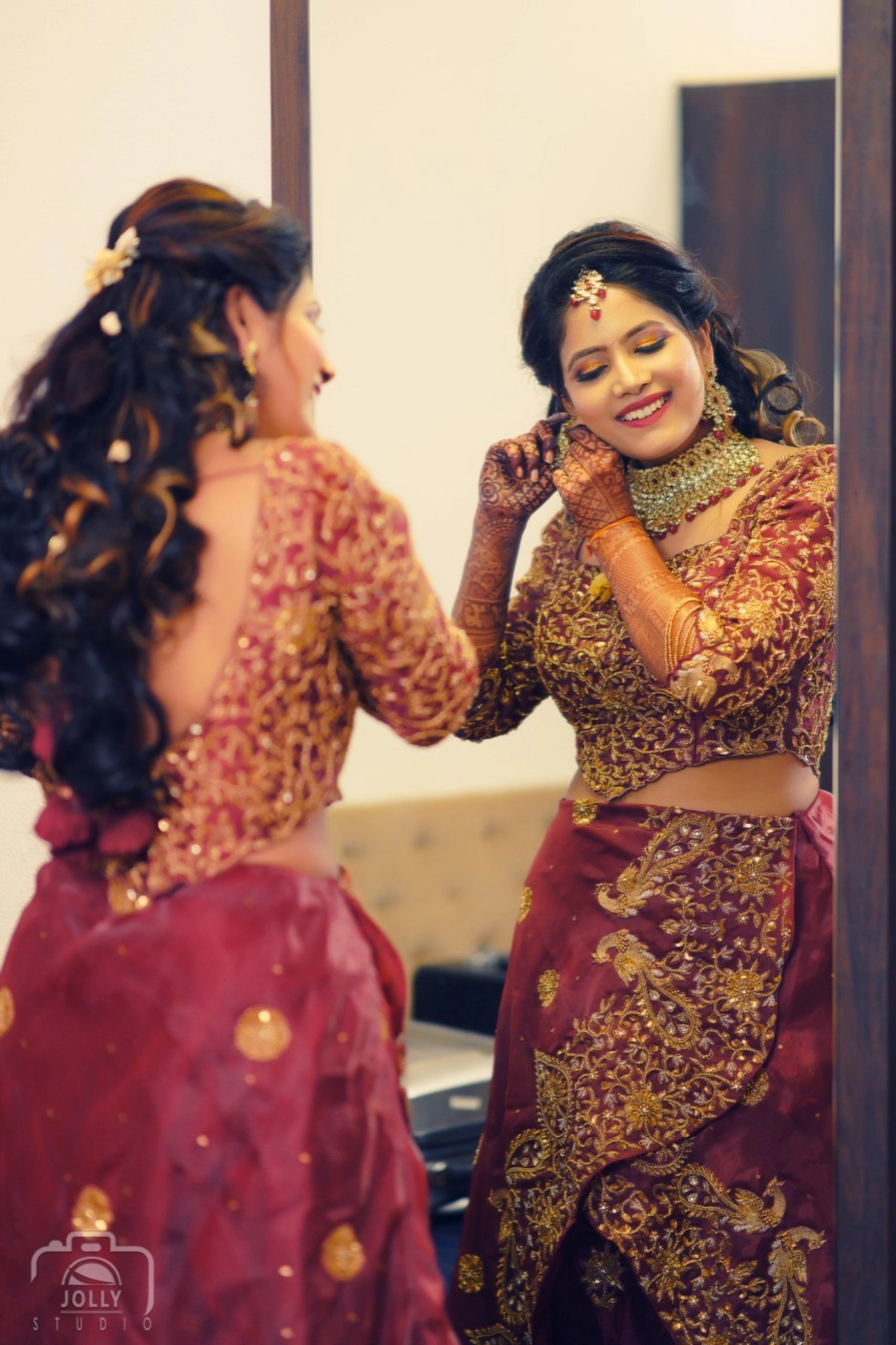 Bride Ankita Singh smiling in a red lehenga intricatelty handcrafted with resham, cutdana, zari and beads by team Archana Karthick.