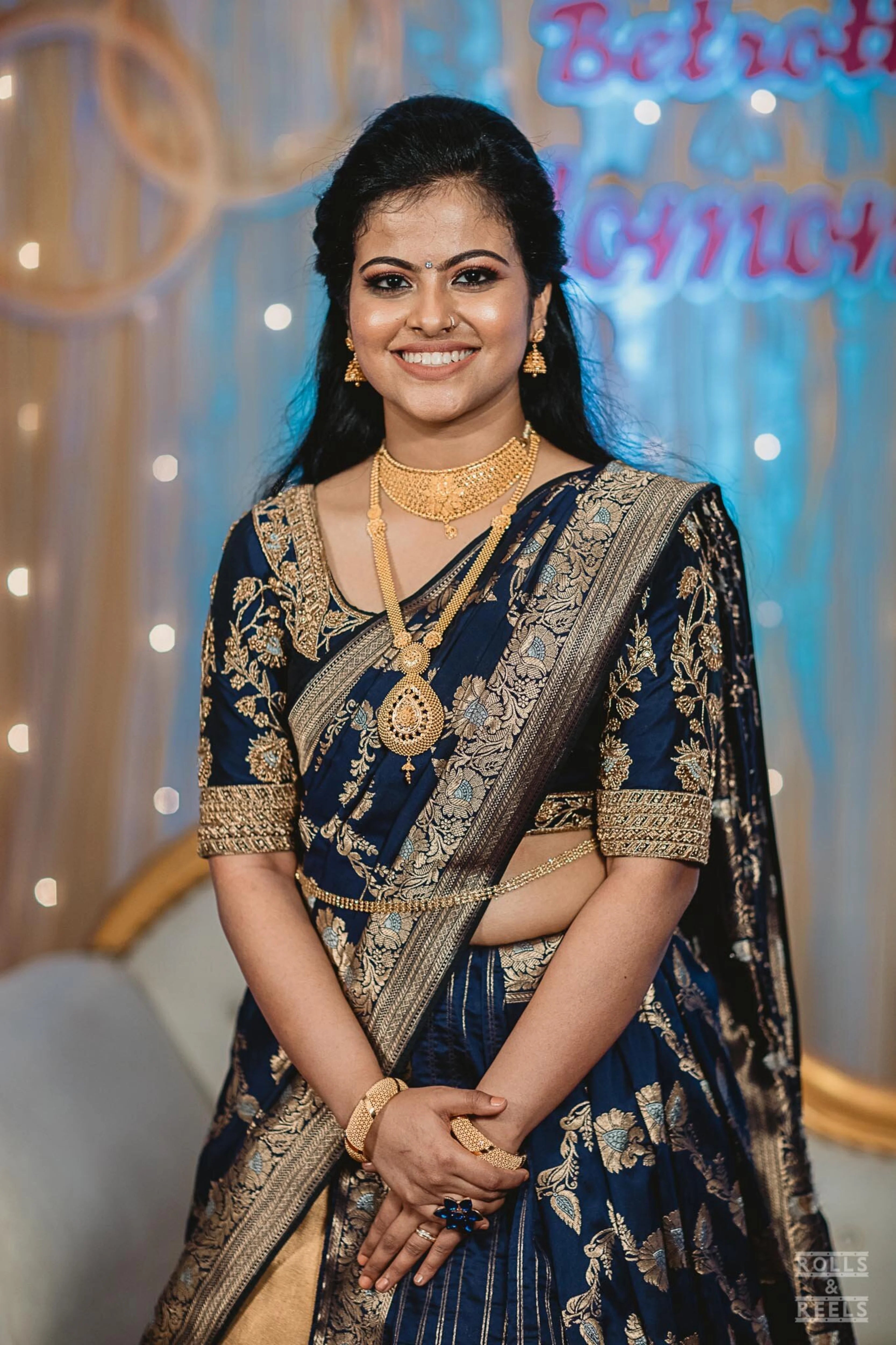 Bride Anu from Kerala in a blue half saree, handcrafted by team Archana Karthick.