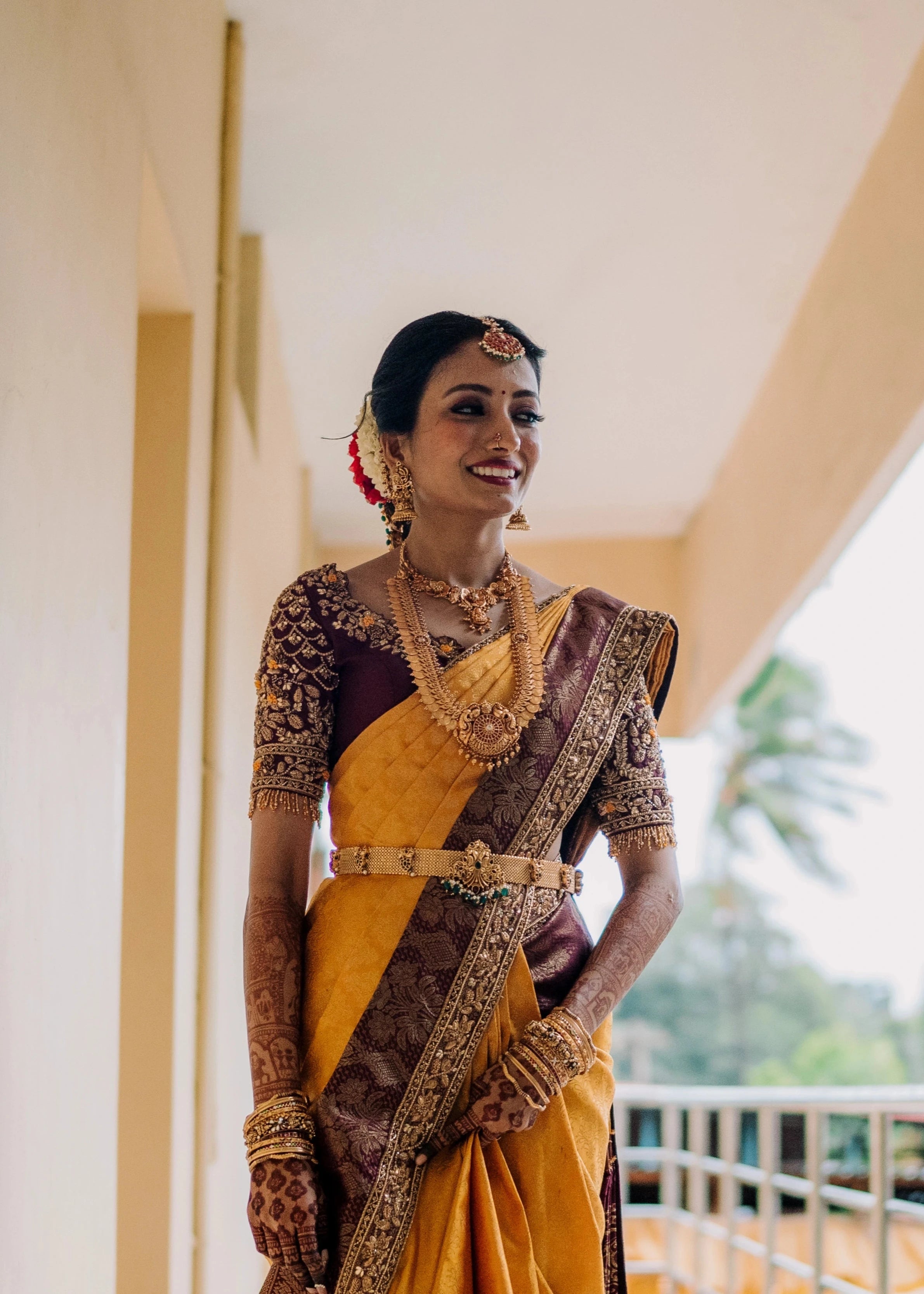 Bride Anusha K laughing during photoshoot in a wine red concept raw silk blouse, veil and saree border, handcrafted with zardosi, beads, resham, crystals, sequins etc by Archana Karthick.