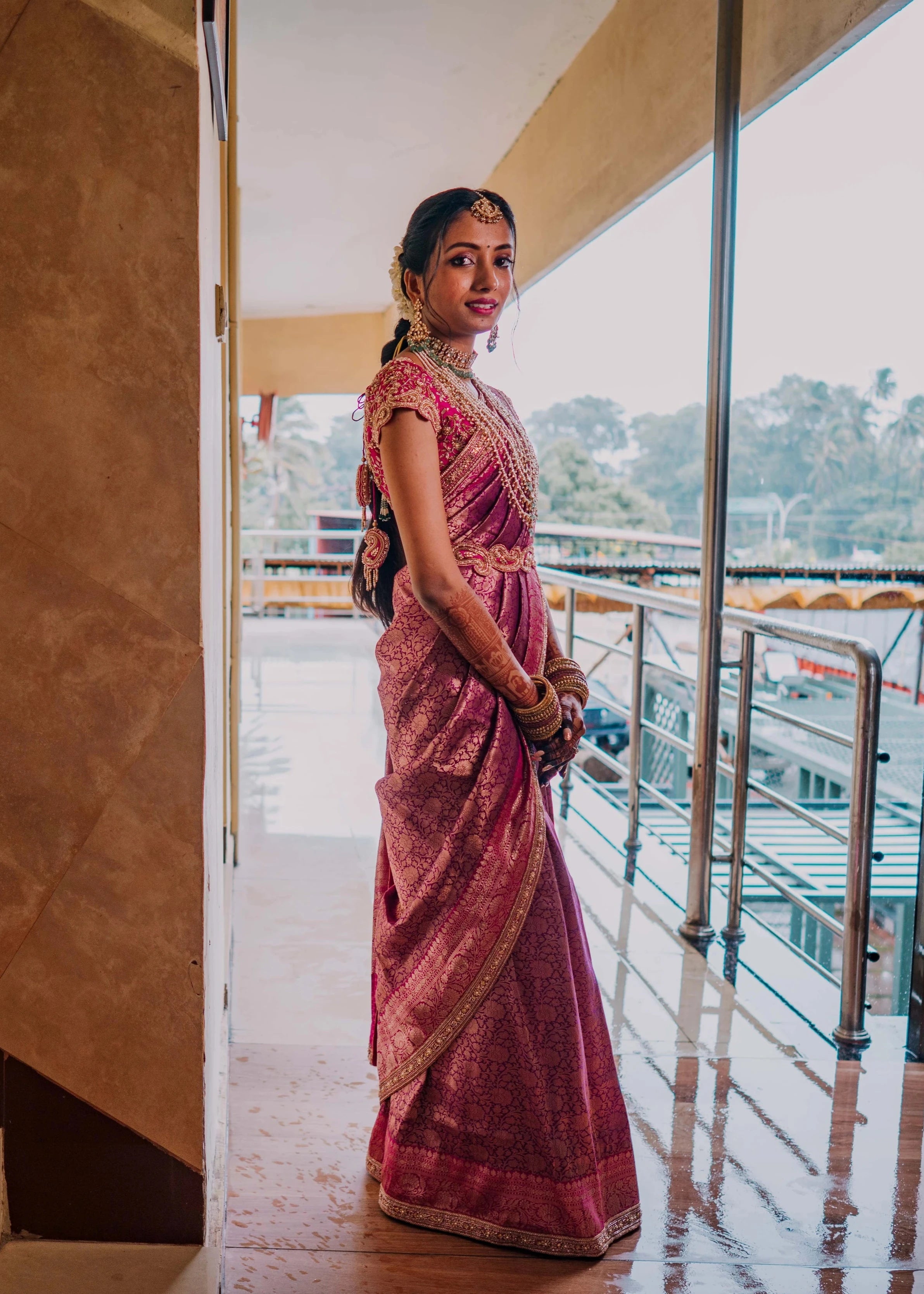 Bride Anusha K looking right in a pink concept raw silk blouse, belt and saree border, handcrafted with zardosi, beads, kundan, cutdana, pearls and sequins by team Archana Karthick