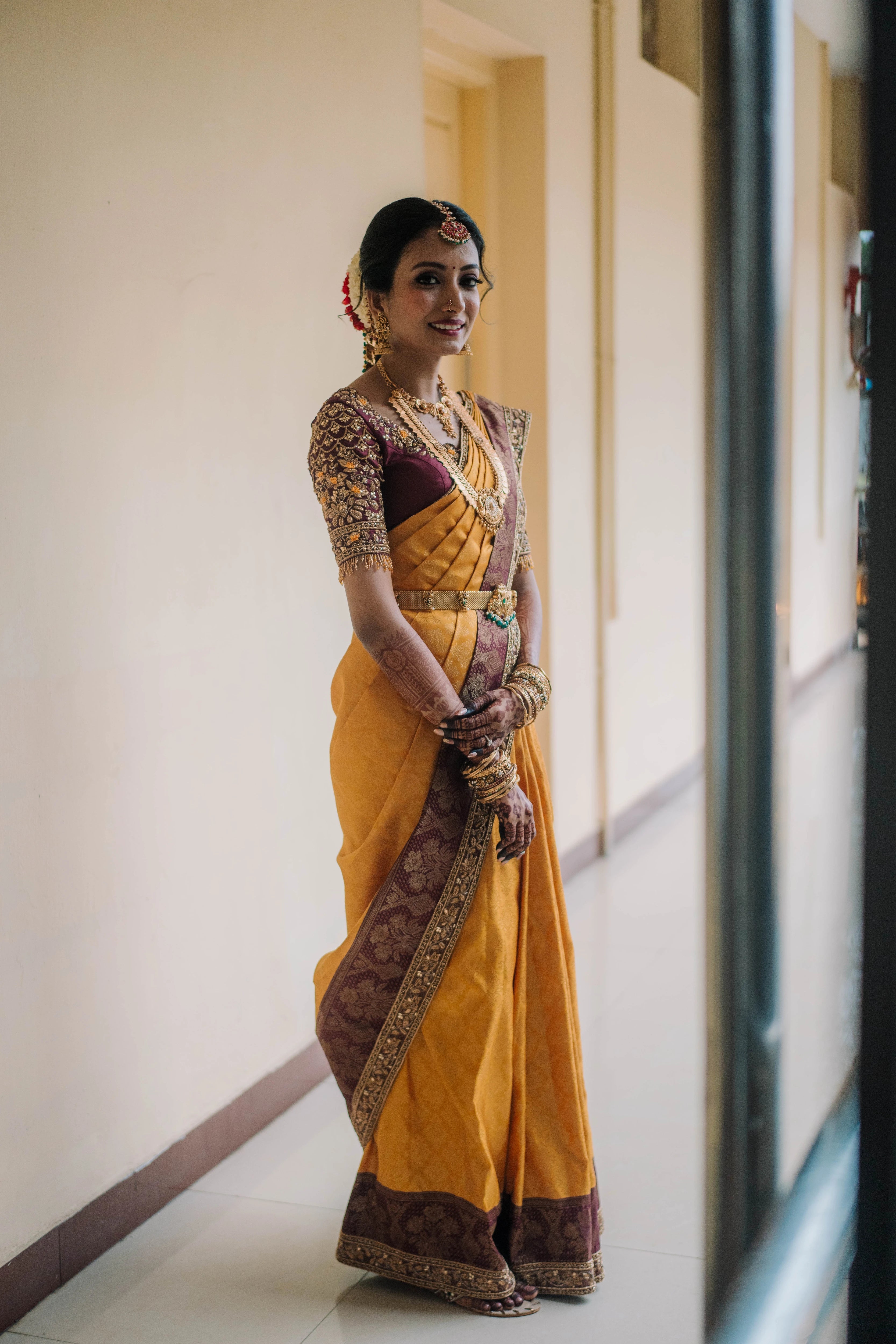 Bride Anusha K posing for photoshoot in a wine red concept raw silk blouse, veil and saree border, handcrafted with zardosi, beads, resham, crystals, sequins etc by Archana Karthick.