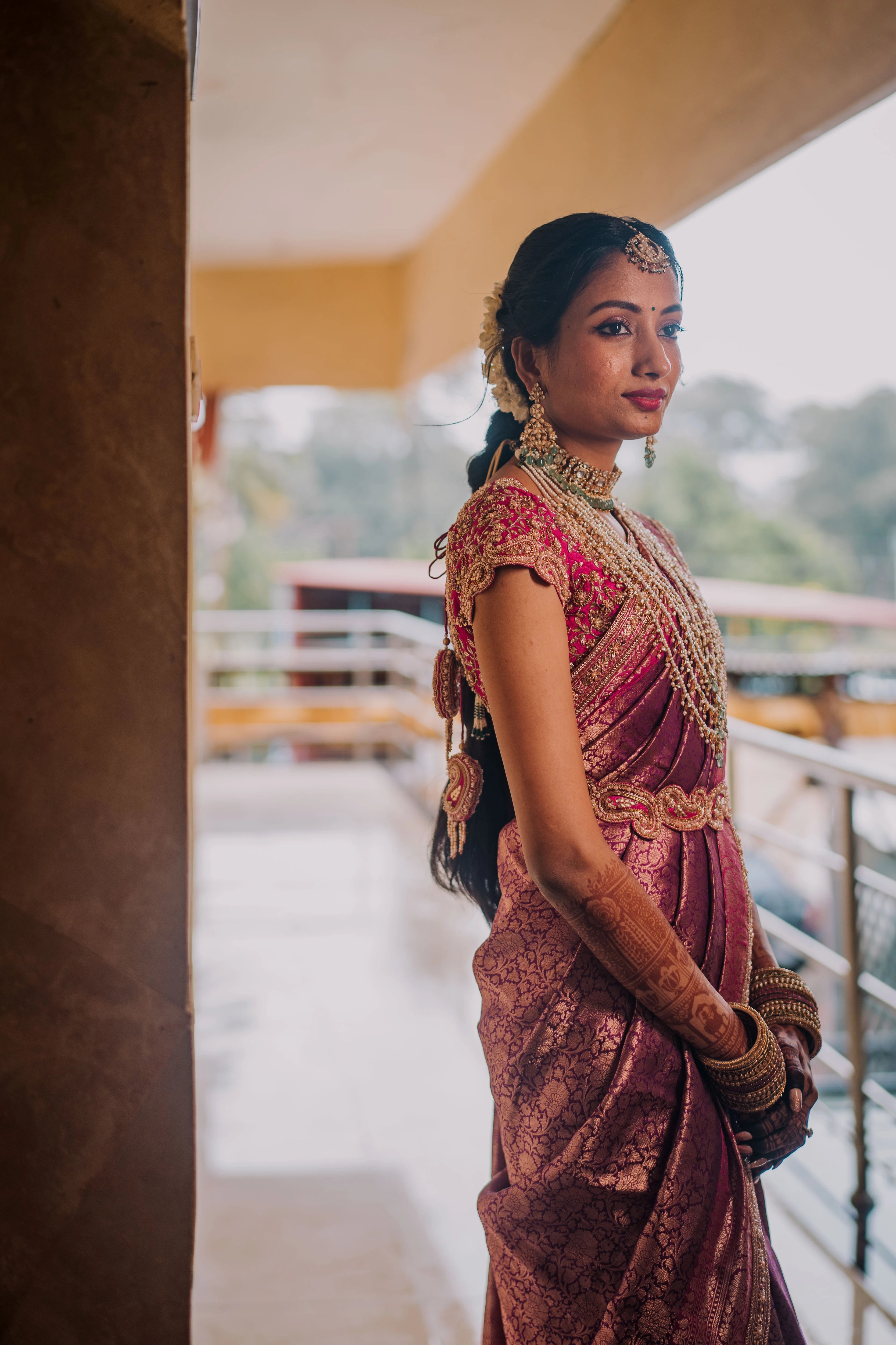 Bride Anusha K posing in a pink concept raw silk blouse, belt and saree border, handcrafted with zardosi, beads, kundan, cutdana, pearls and sequins by team Archana Karthick