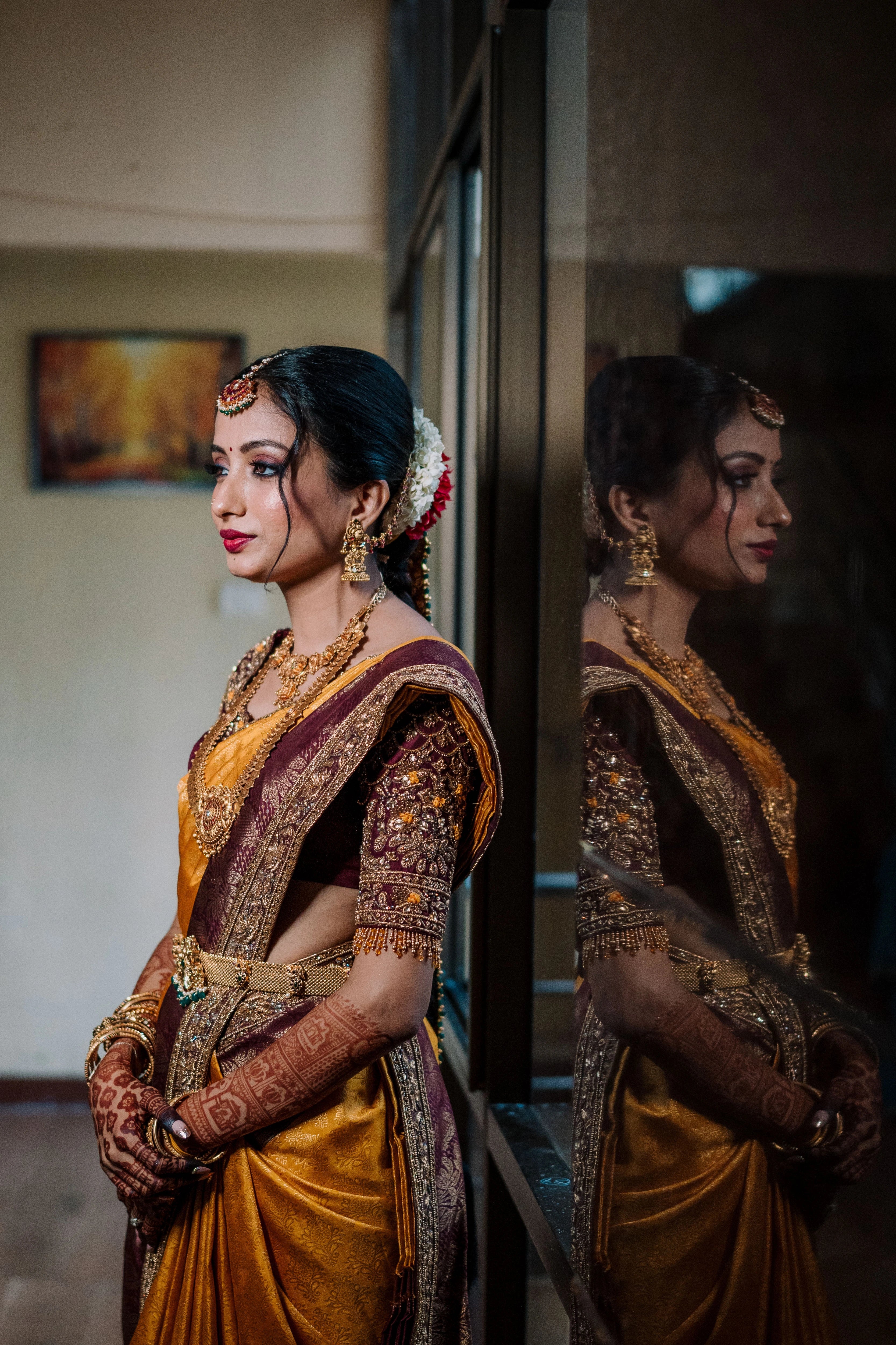 Bride Anusha K posing in a wine red concept raw silk blouse, veil and saree border, handcrafted with zardosi, beads, resham, crystals, sequins etc by Archana Karthick.
